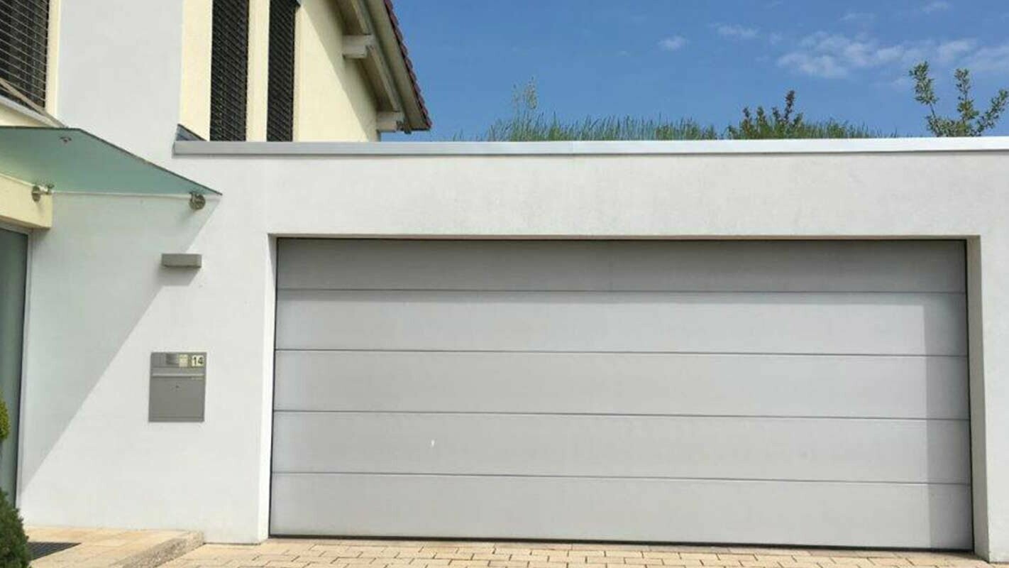 Garage before renovation with PREFA sidings in anthracite, white façade and white garage door
