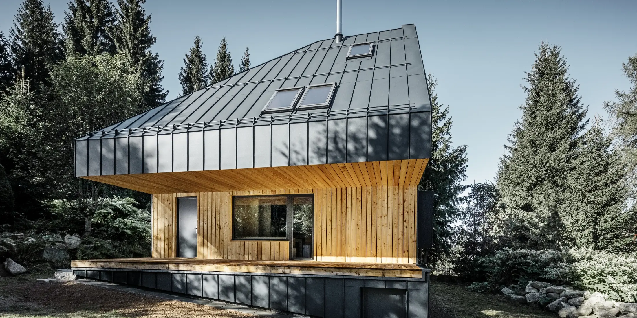 Architecturally designed detached house in the forest, the imposing roof was clad with PREFALZ aluminium from PREFA in anthracite. The soffit and the façade are clad with wooden panels.