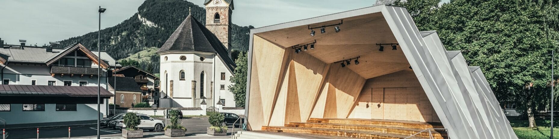 General view of the music pavilion of Kirchdorf and in the background the church of the parish