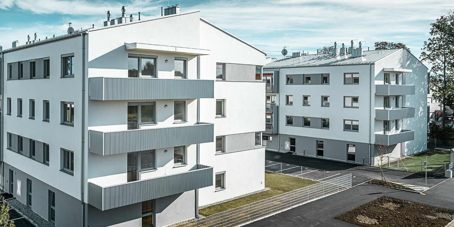 Modern apartment complex with white façade and balconies with PREFA serrated profile in metallic silver
