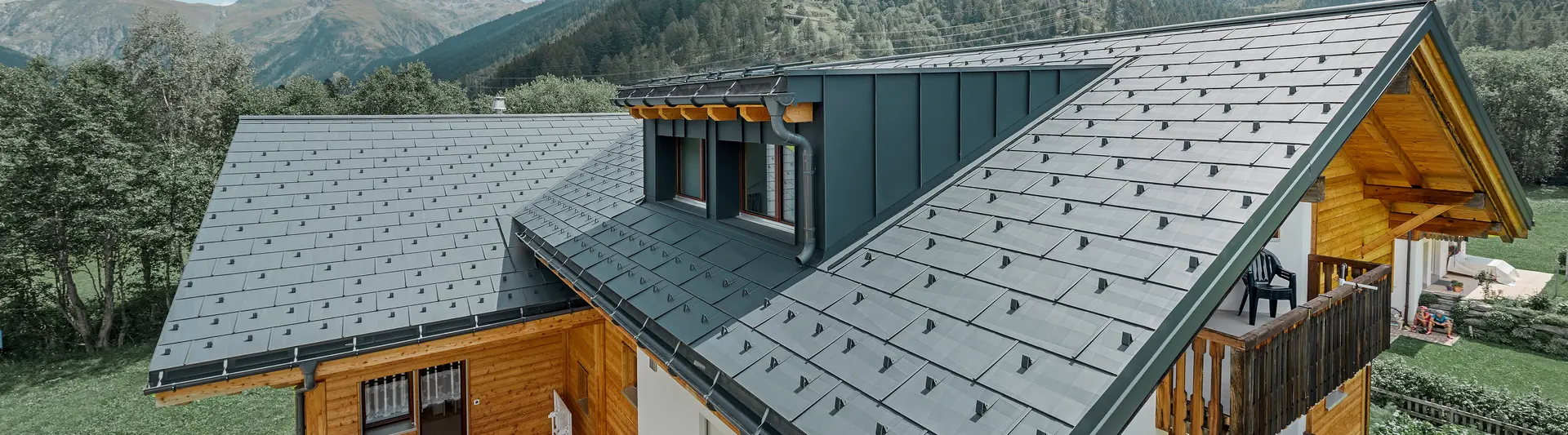 Newly refurbished residential building with gabled roof and dormer. The roof was refurbished with the PREFA FX.12 roof panel in anthracite.
