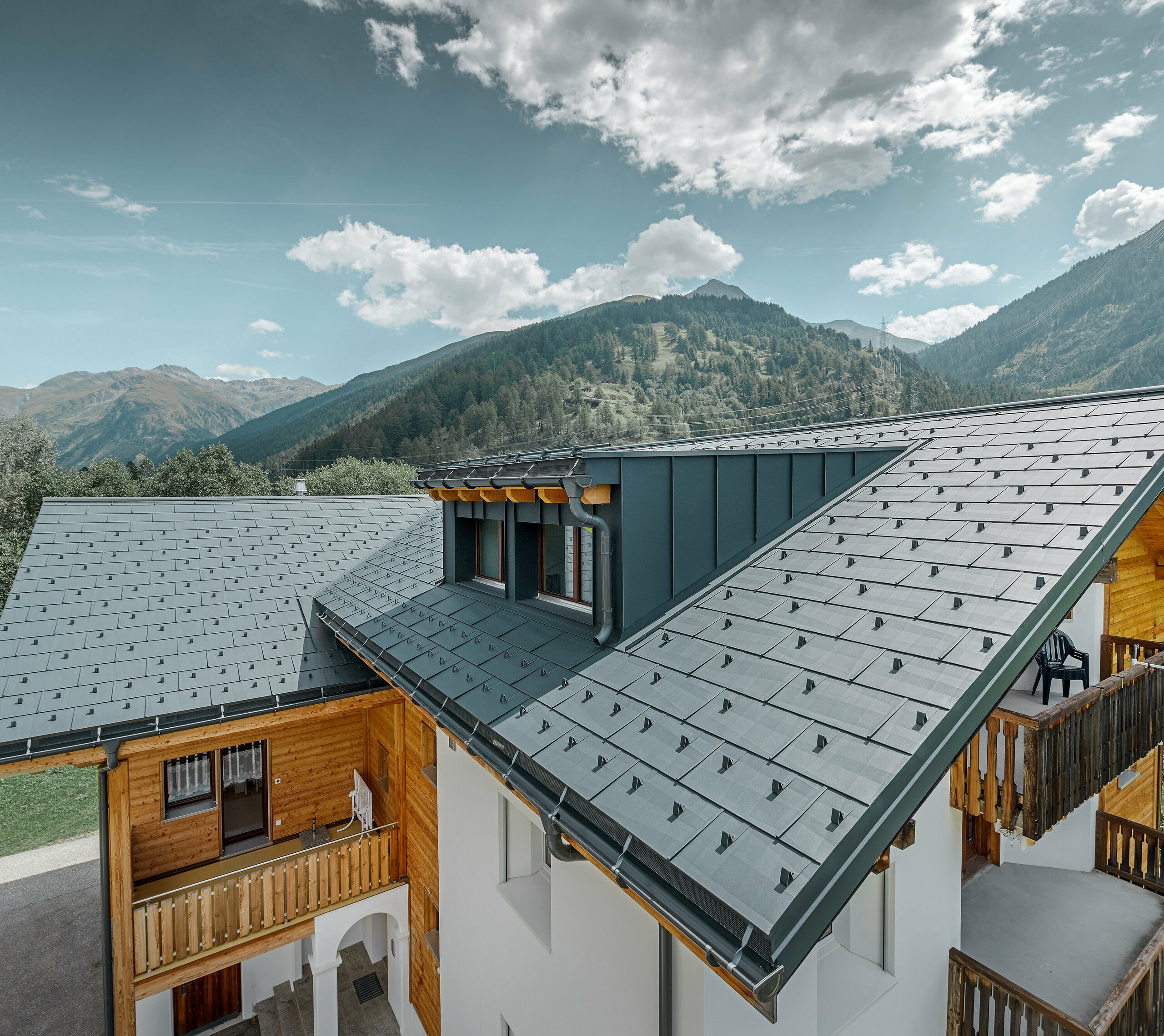 Newly refurbished residential building with gabled roof and dormer. The roof was refurbished with the PREFA FX.12 roof panel in anthracite.