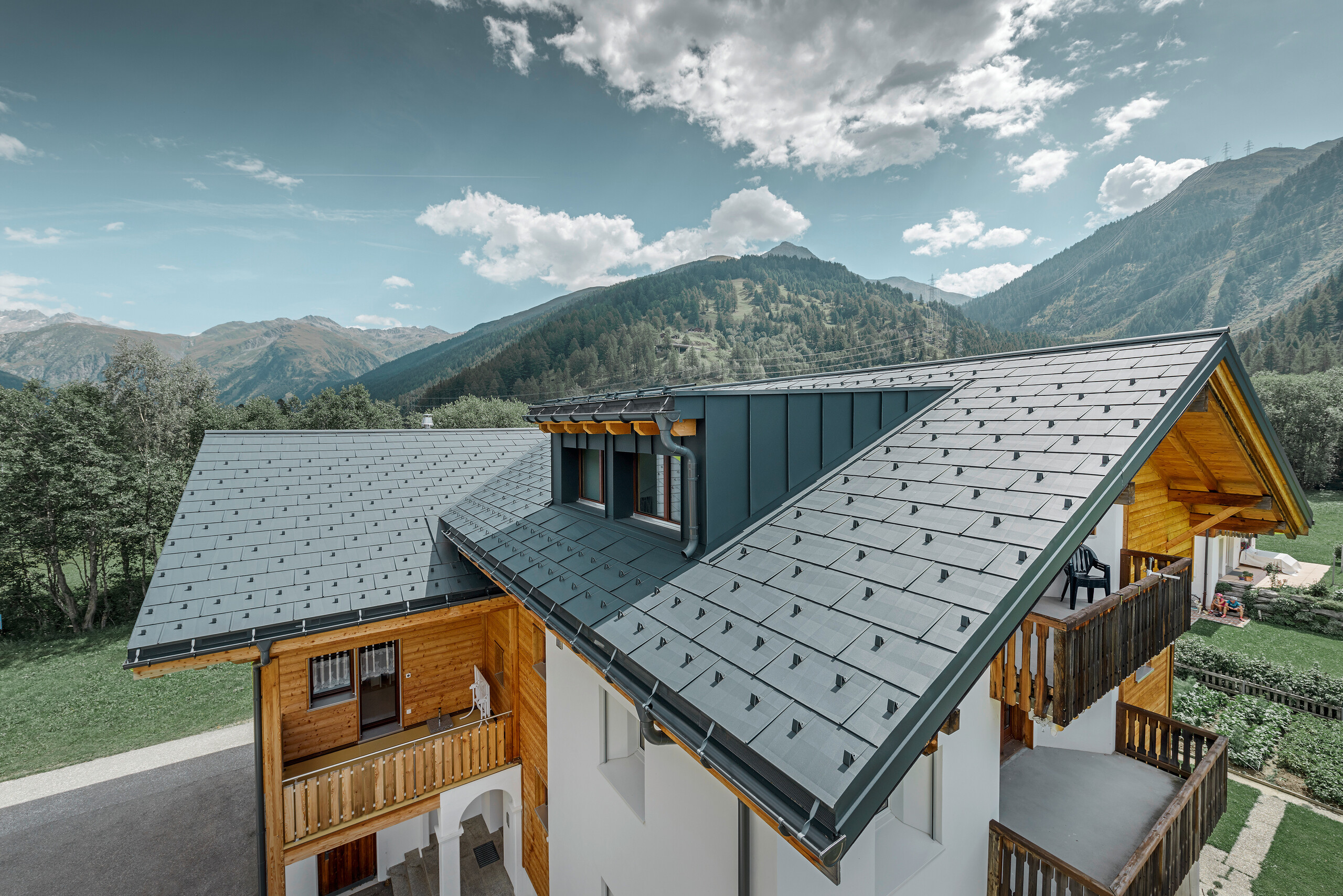 Newly refurbished residential building with gabled roof and dormer. The roof was refurbished with the PREFA FX.12 roof panel in anthracite.