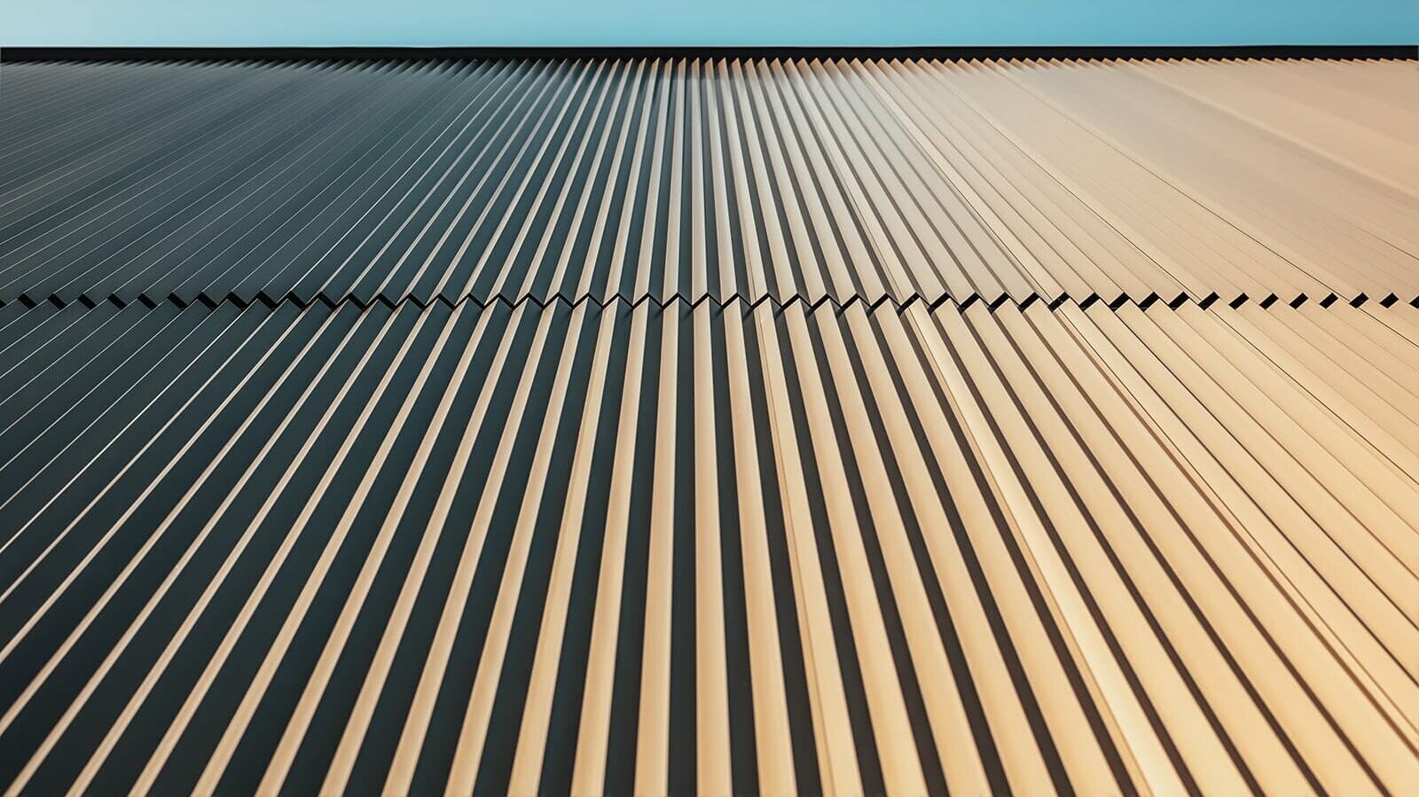 Worm´s eye view of the PREFA façade which was covered with the serrated profile in bronze. The view is up to the sky.