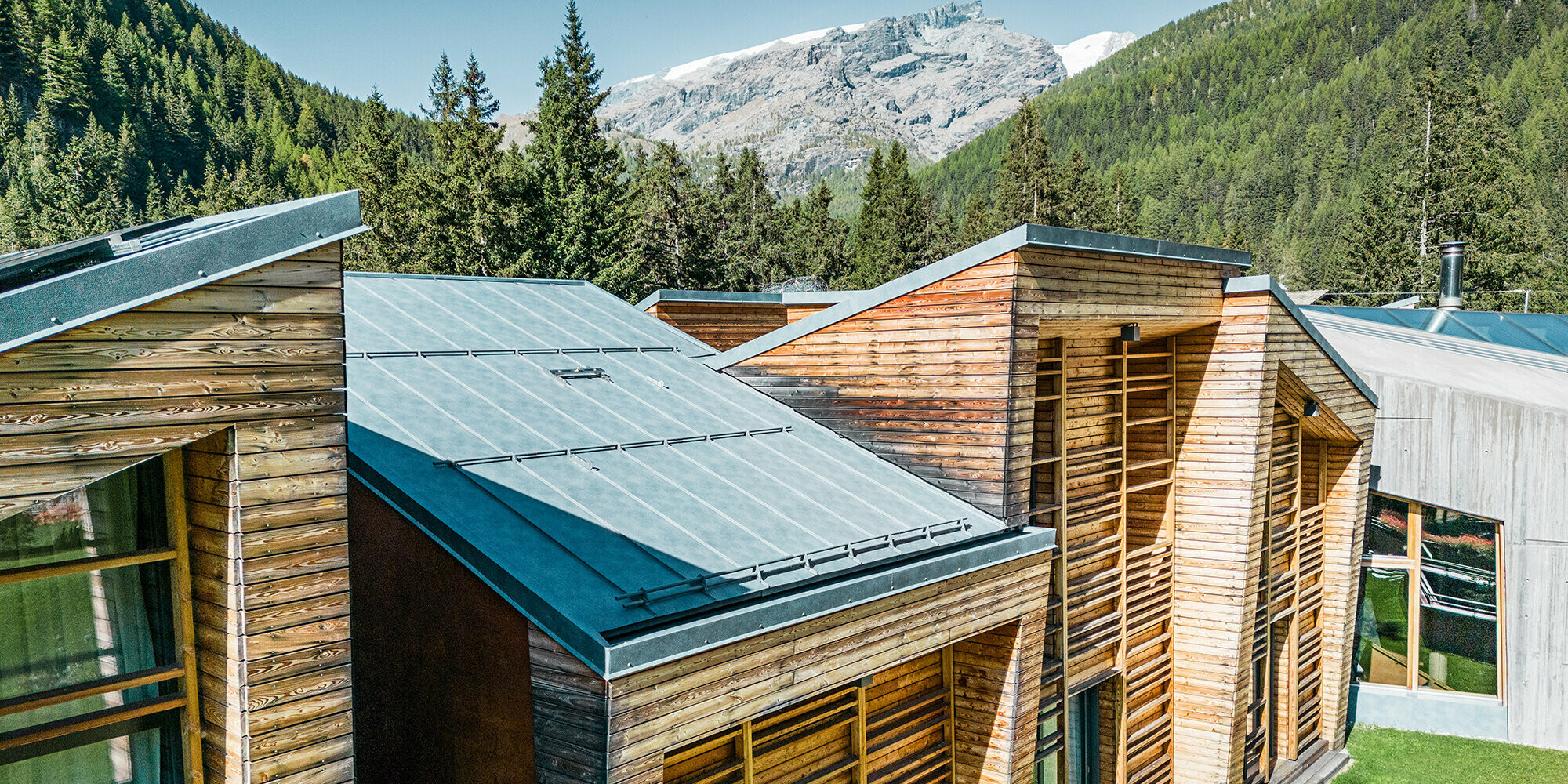 Lateral detail view of the roofscape, the wooden façade and the carefully laid Prefalz sheets are clearly visible.