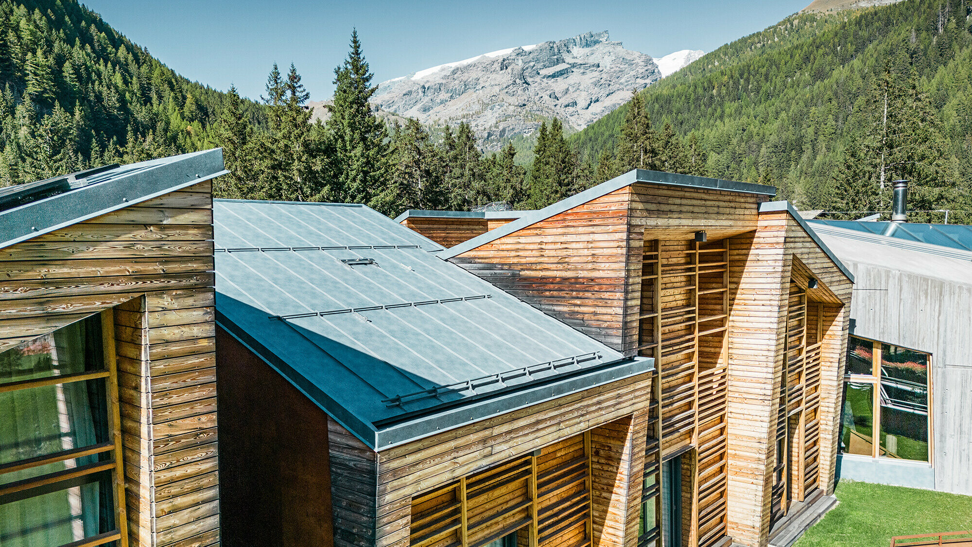 Lateral detail view of the roofscape, the wooden façade and the carefully laid Prefalz sheets are clearly visible.