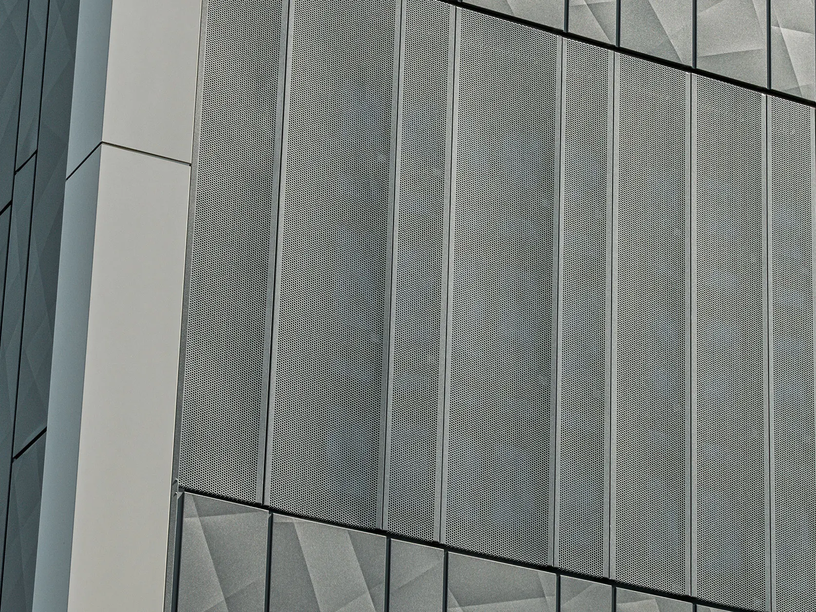 Facade view of a Eurospar supermarket in Rohrbach with PREFA Siding.X and perforated sidings in anthracite. The Siding.X elements feature a lively, geometric joint pattern, while the perforated Sidings offer a modern, air-permeable structure.