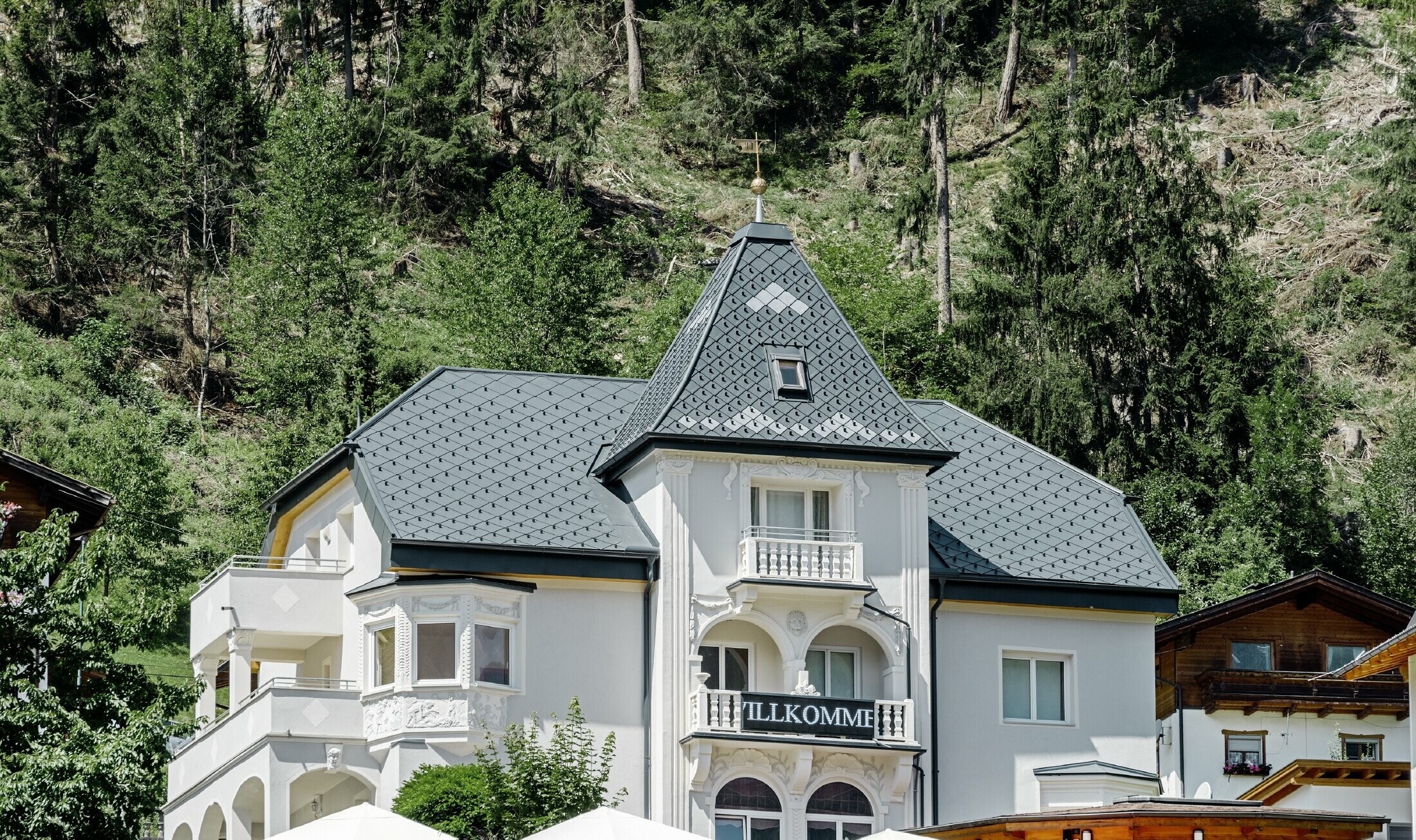 Rock cabin with a tower and an aluminium roof in anthracite with a Pizzeria on the ground floor