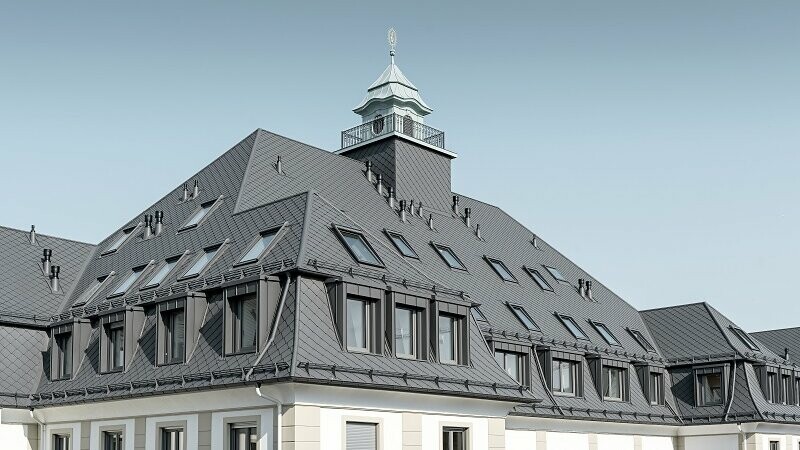 Lateral view of the "Marie" project, an old hospital was converted and renovated into a residential complex. The buildings are roofed in rhomboid roof tiles 29x 29 and Prefalz in dark grey.