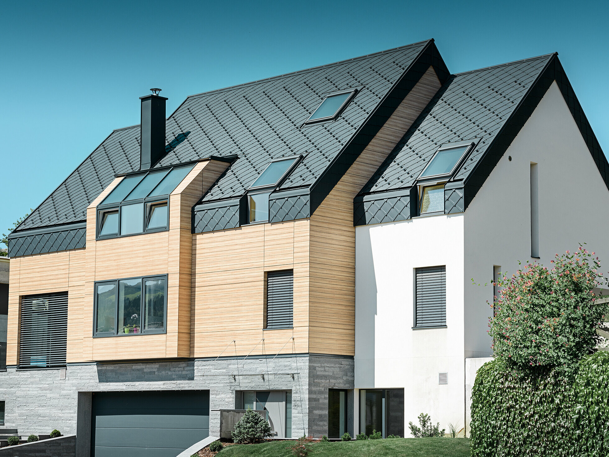 Contemporary new building, where the roof covering also extends over the upper part of the façade, aluminium rhomboid roof tiles in anthracite were used as roof cladding