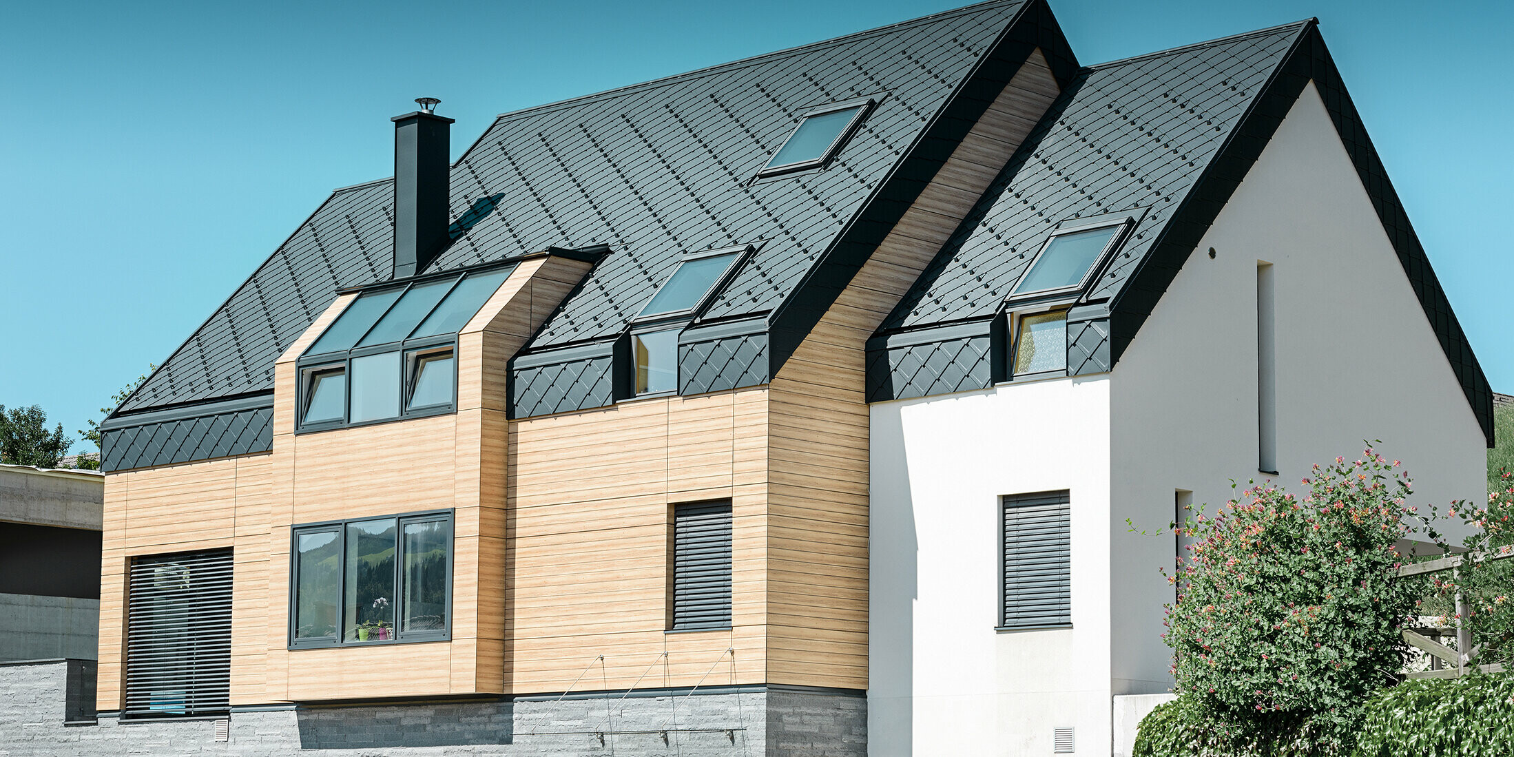 Contemporary new building, where the roof covering also extends over the upper part of the façade, aluminium rhomboid roof tiles in anthracite were used as roof cladding