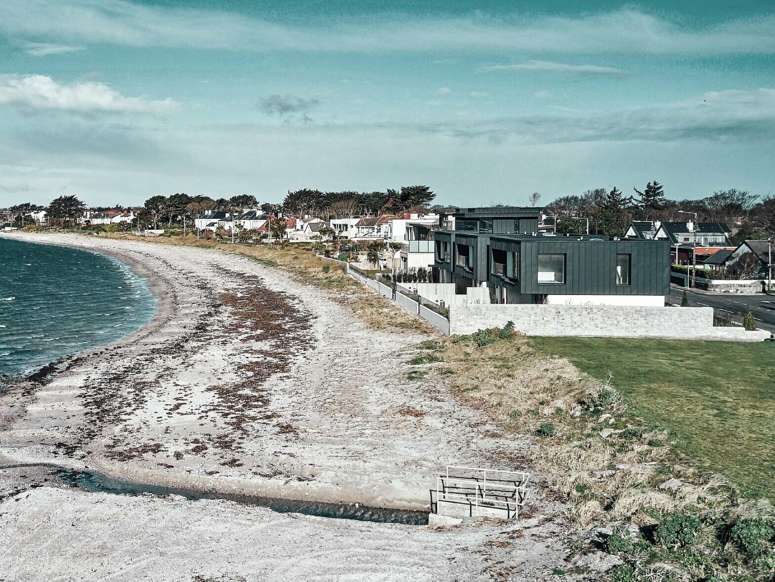 Picture of the residential houses on the beach. On the left side you can see the sea, on the right side the terraced houses can be seen.