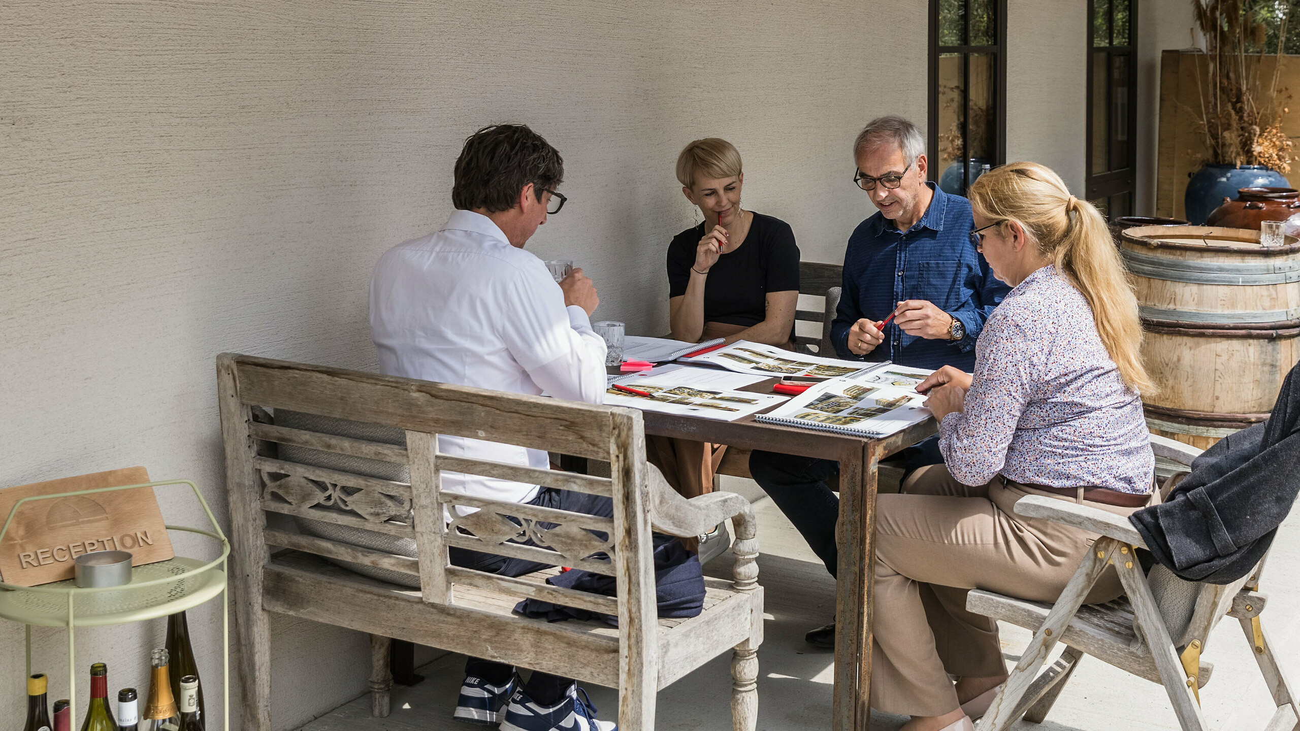 Small working group at the PREFARENZEN 2026 expert dialogue in the winegrower's residence in Seewinkel, Burgenland: Judit Nemere (Managing Director of PREFA Hungary), Veronika Roll (Marketing PREFA Austria), Sven Disser (Head of Development, Bauwerk) and Wolfgang Croce (Croce & Wir, Graz) discuss the design quality of the architectural projects submitted. The focus is on the creative use of PREFA aluminium solutions in contemporary architecture. The relaxed atmosphere encourages concentrated discussion about innovation, functionality and context.