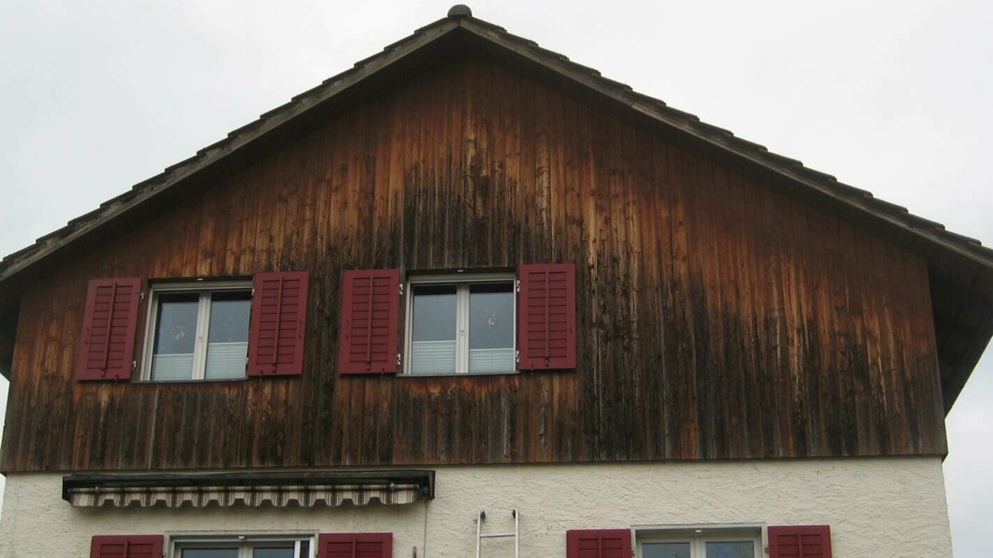House façade with weathered wood before renovation with PREFA sidings