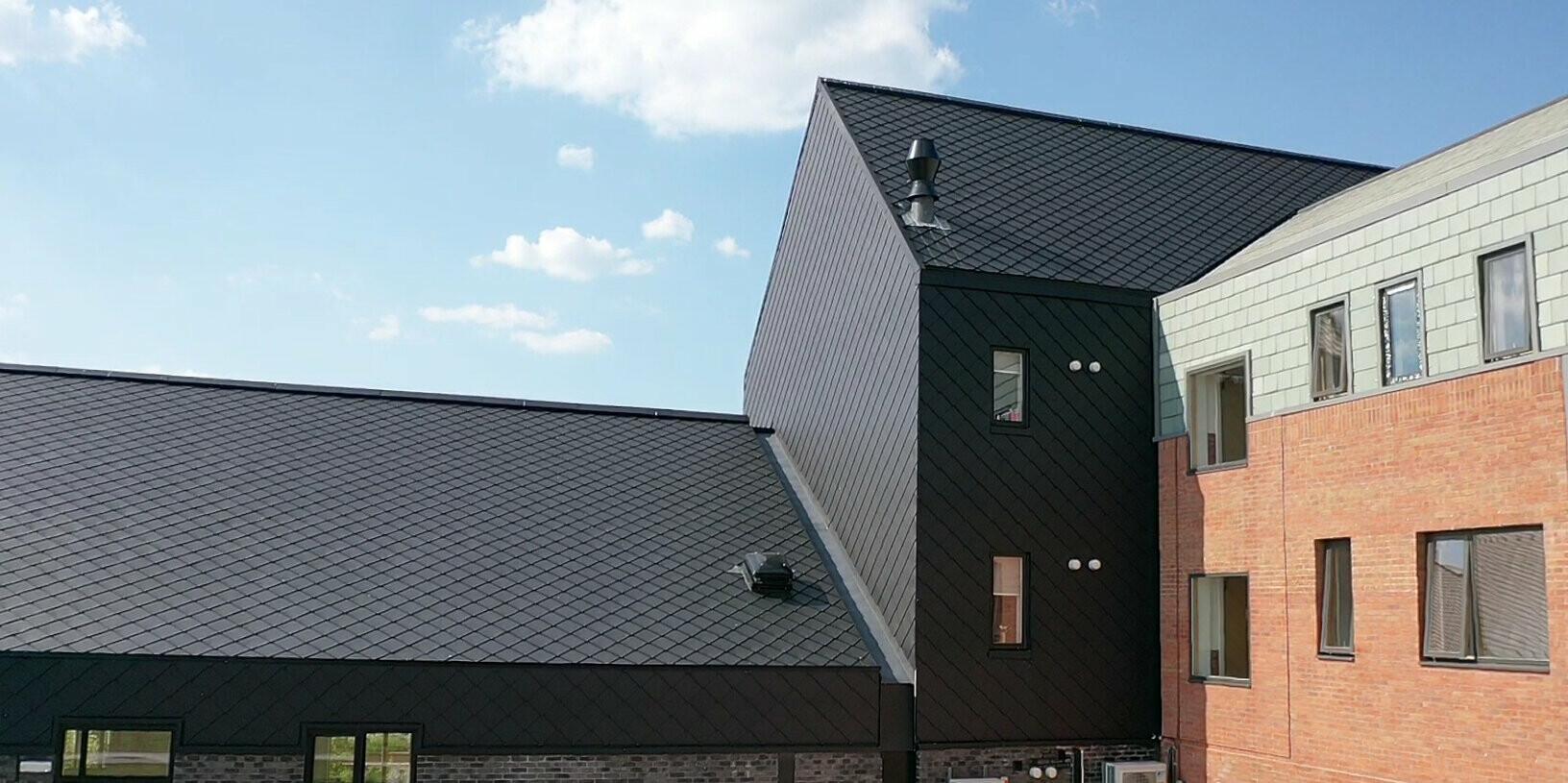 PREFA rhomboid tile 29 × 29 in P.10 Black on the building of a care facility in Preston