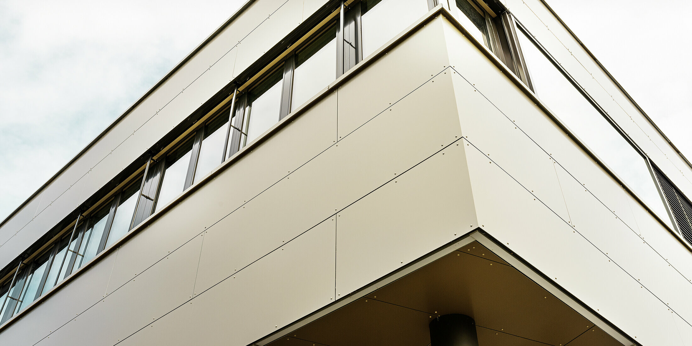 Modern annex building accommodating Guggisberg’s workshop and offices with PREFA aluminium composite panels in bronze