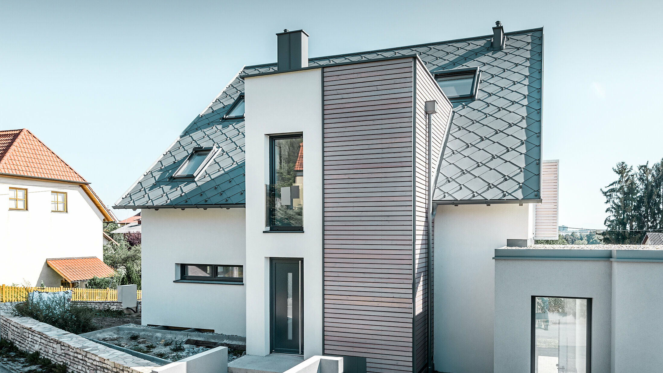 The detached house with gabled roof in Leonding was completely refurbished. The roof area was covered with the PREFA 44 x 44 rhomboid roof tiles in light grey, including snow guards. The PREFA hanging gutter, also in light grey, was used for the guttering. 