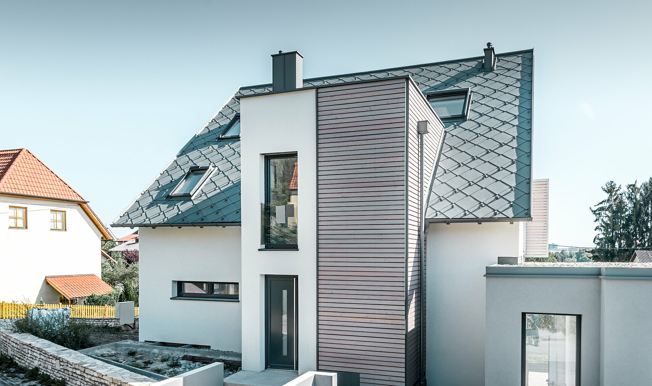 The detached house with gabled roof in Leonding was completely refurbished. The roof area was covered with the PREFA 44 x 44 rhomboid roof tiles in light grey, including snow guards. The PREFA hanging gutter, also in light grey, was used for the guttering. 