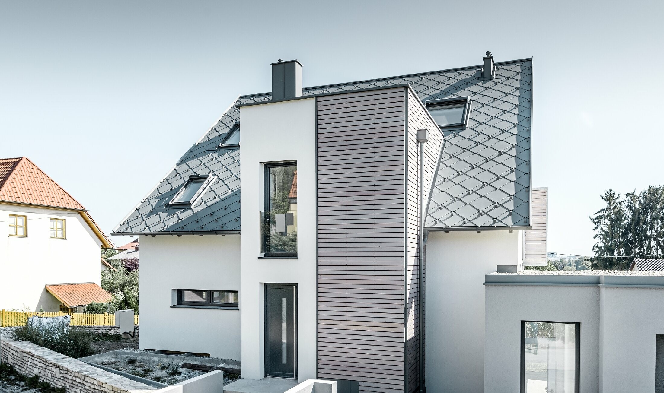 The detached house with gabled roof in Leonding was completely refurbished. The roof area was covered with the PREFA 44 x 44 rhomboid roof tiles in light grey, including snow guards. The PREFA hanging gutter, also in light grey, was used for the guttering. 