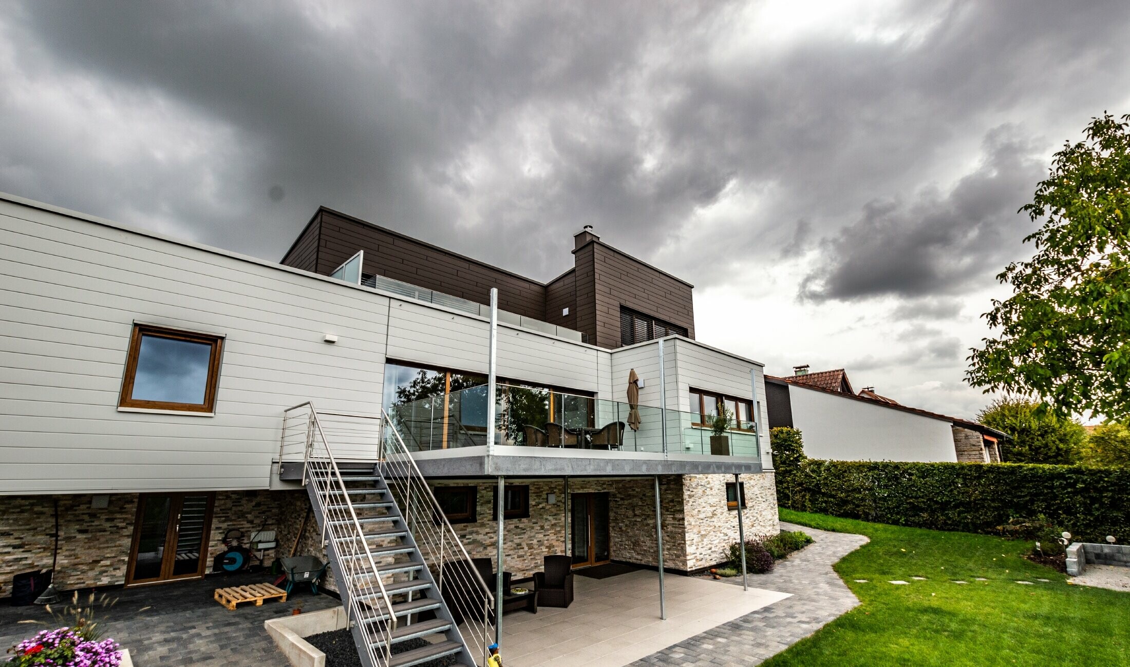 Residential building with flat roof and white and brown façade with horizontally installed PREFA sidings.