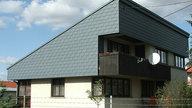 Single-pitch roof with façade cladding on top floor. The façade has been clad with PREFA façade shingles.