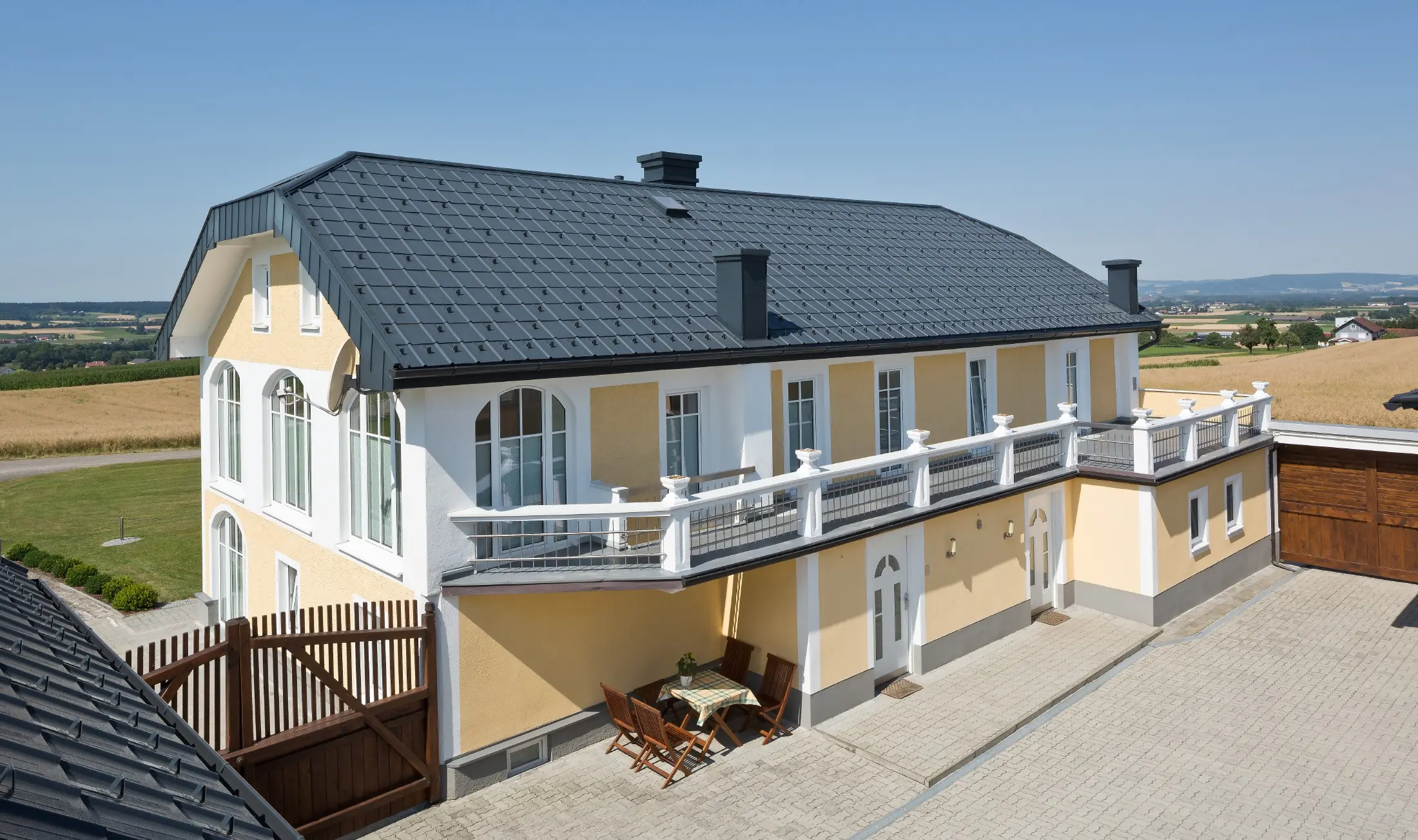 Newly renovated farmhouse with anthracite roof tiles and newly renovated plaster façade.