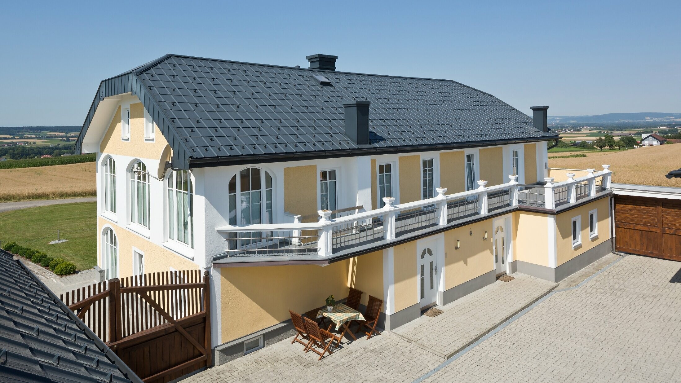 Newly renovated farmhouse with anthracite roof tiles and newly renovated plaster façade.