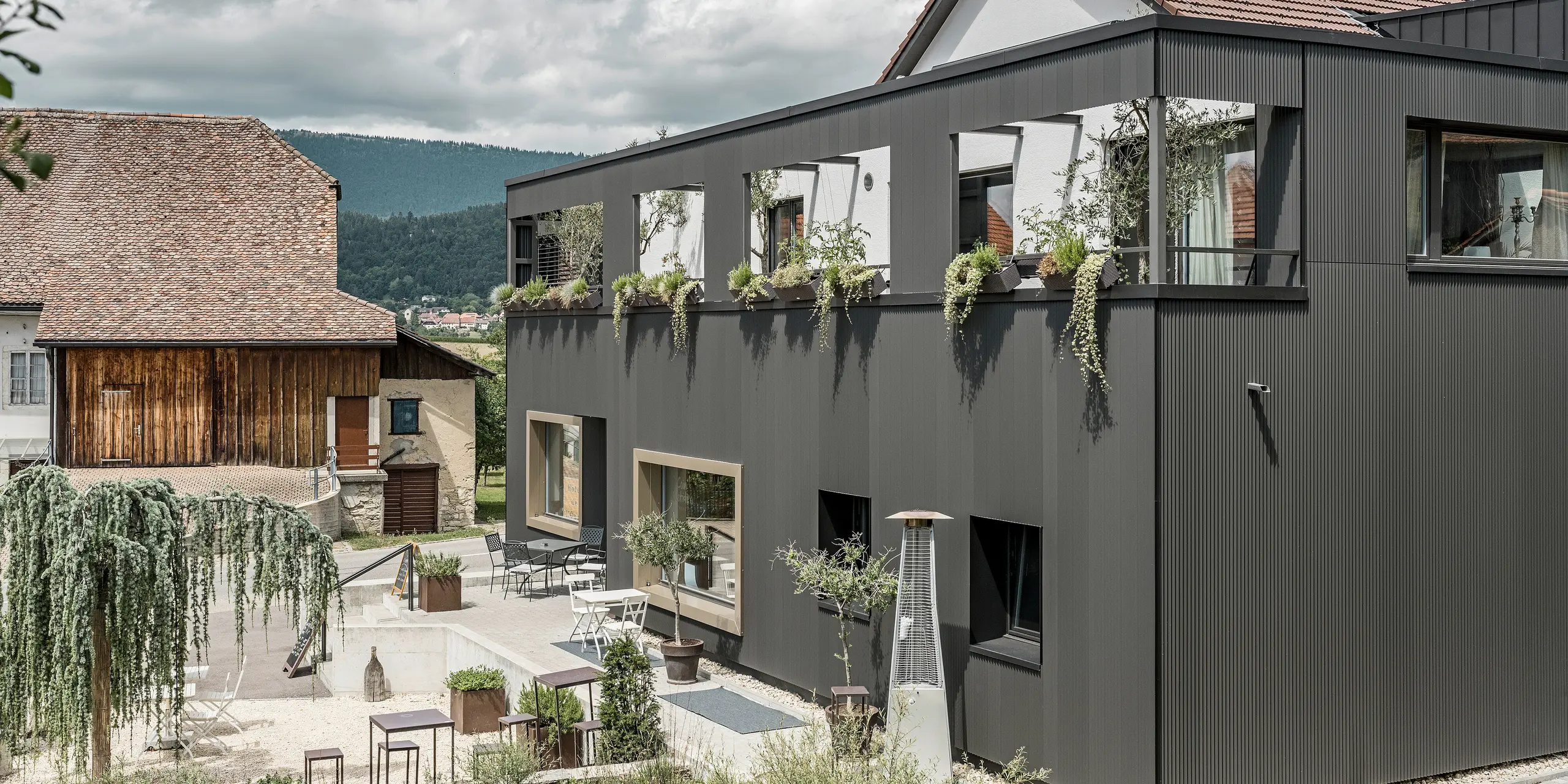 PREFA serrated profile in the special colour black grey on the Hôtel de l’Ours in Prêles, Switzerland