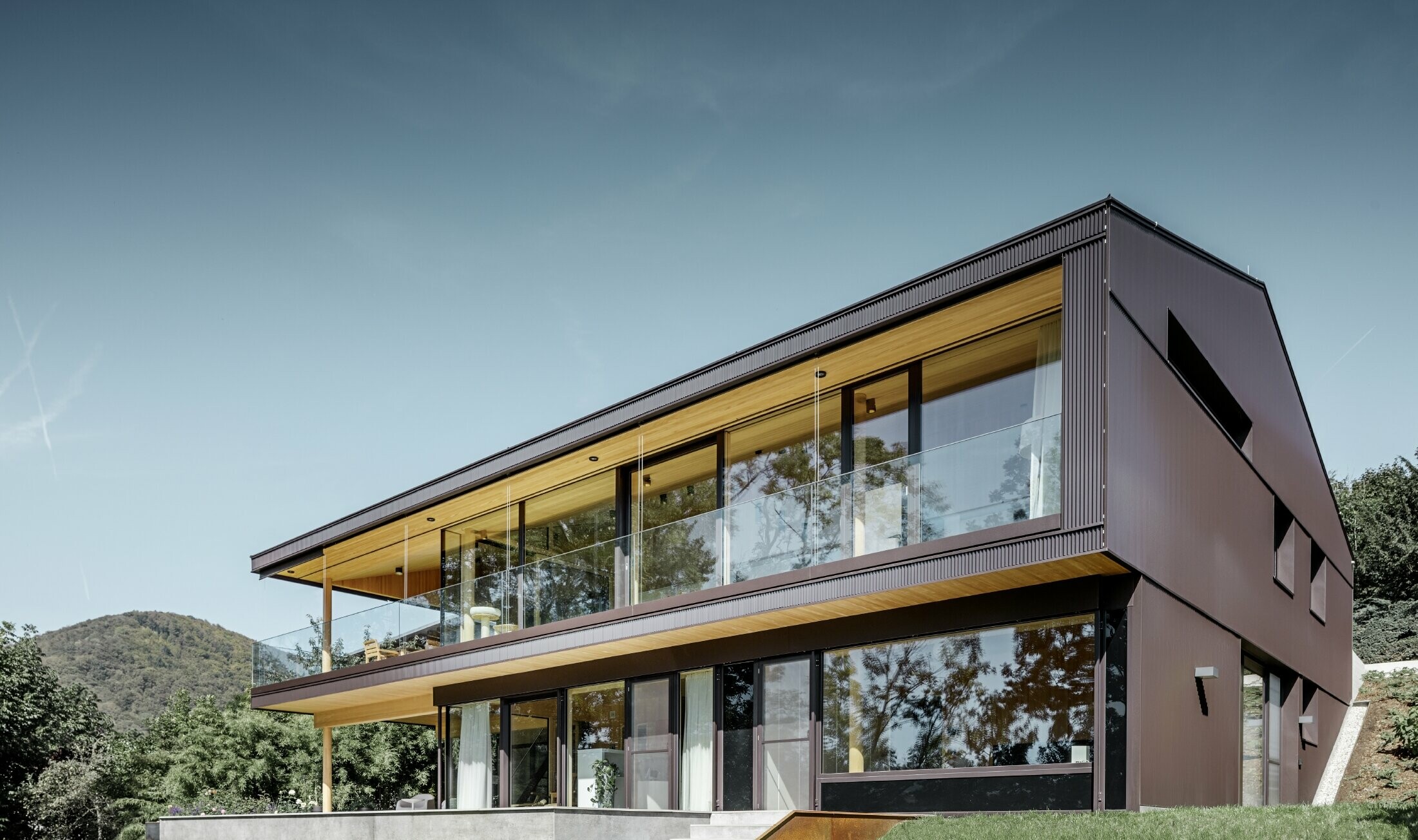 Modern detached house with large windows on the garden side; the façade was clad in the PREFA zig-zag profile in dark brown.