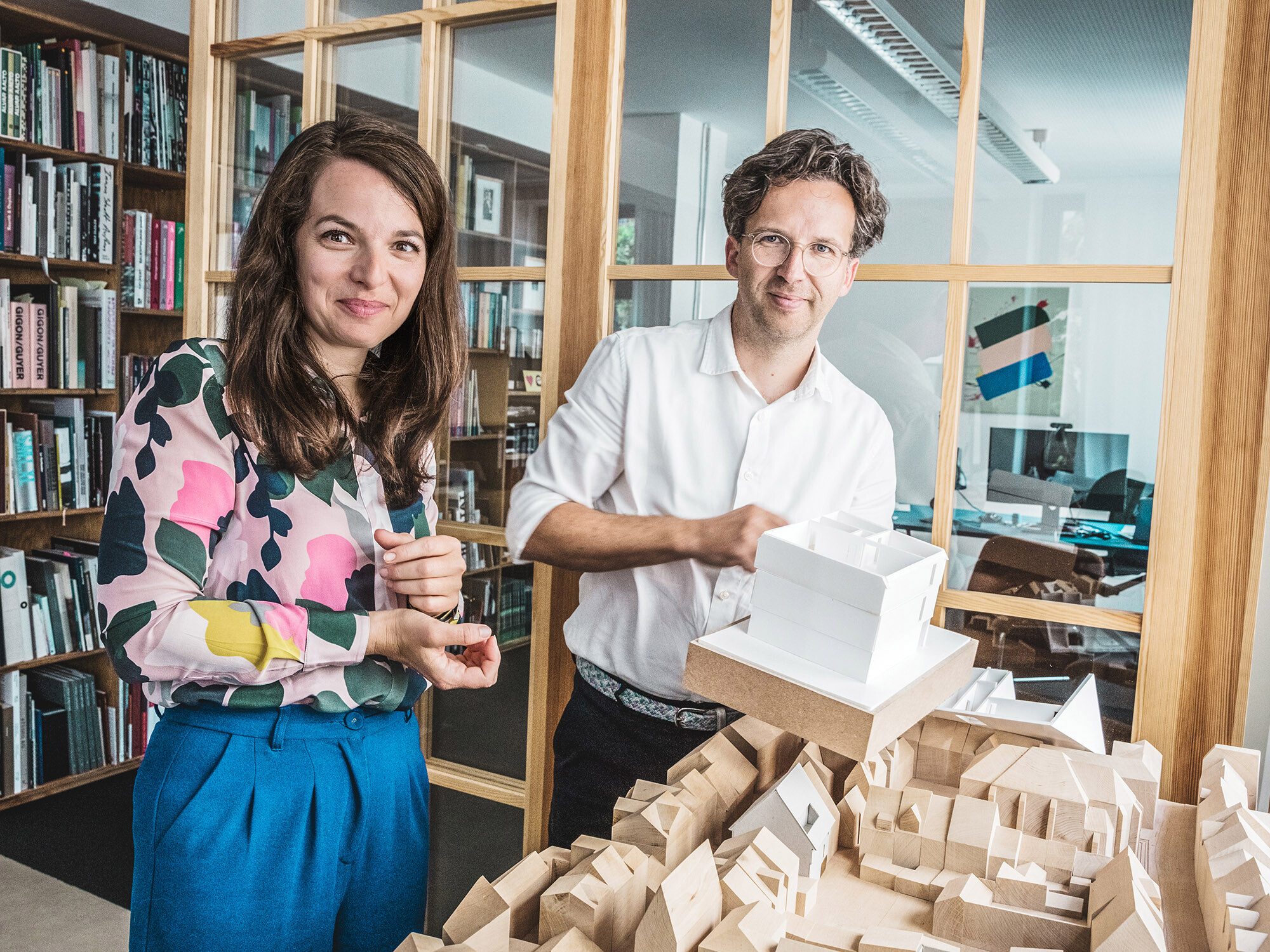 Portrait of the architects Silvia Schellenberg-Thaut and Sebastian Thaut from Atelier ST with models at their office.