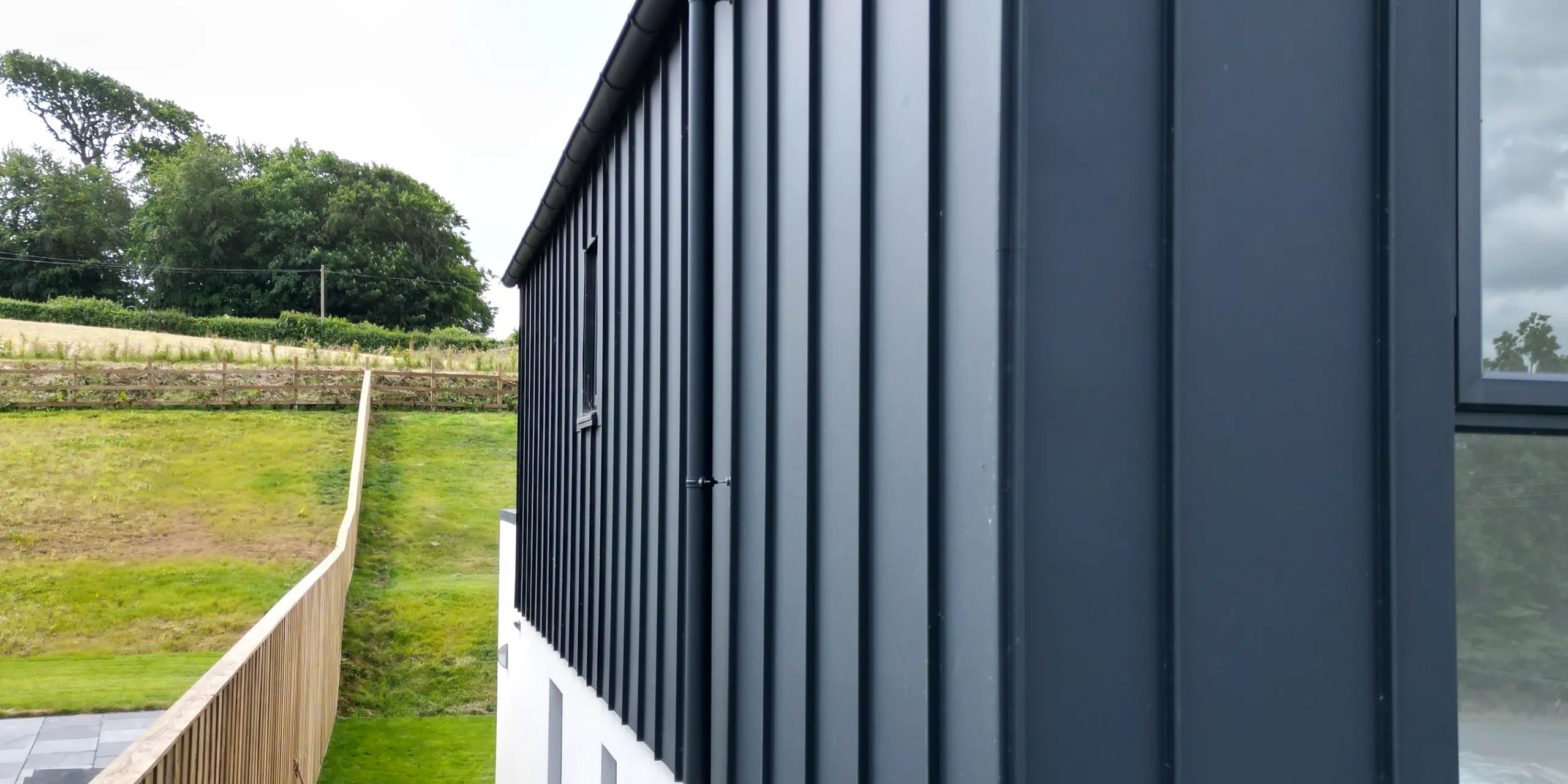 Close-up of the PREFALZ standing seam façade in P.10 anthracite, which highlights the high-quality aluminium and the precise workmanship of the standing seam covering. The clear lines and the UV-resistant surface make this façade a modern eye-catcher.