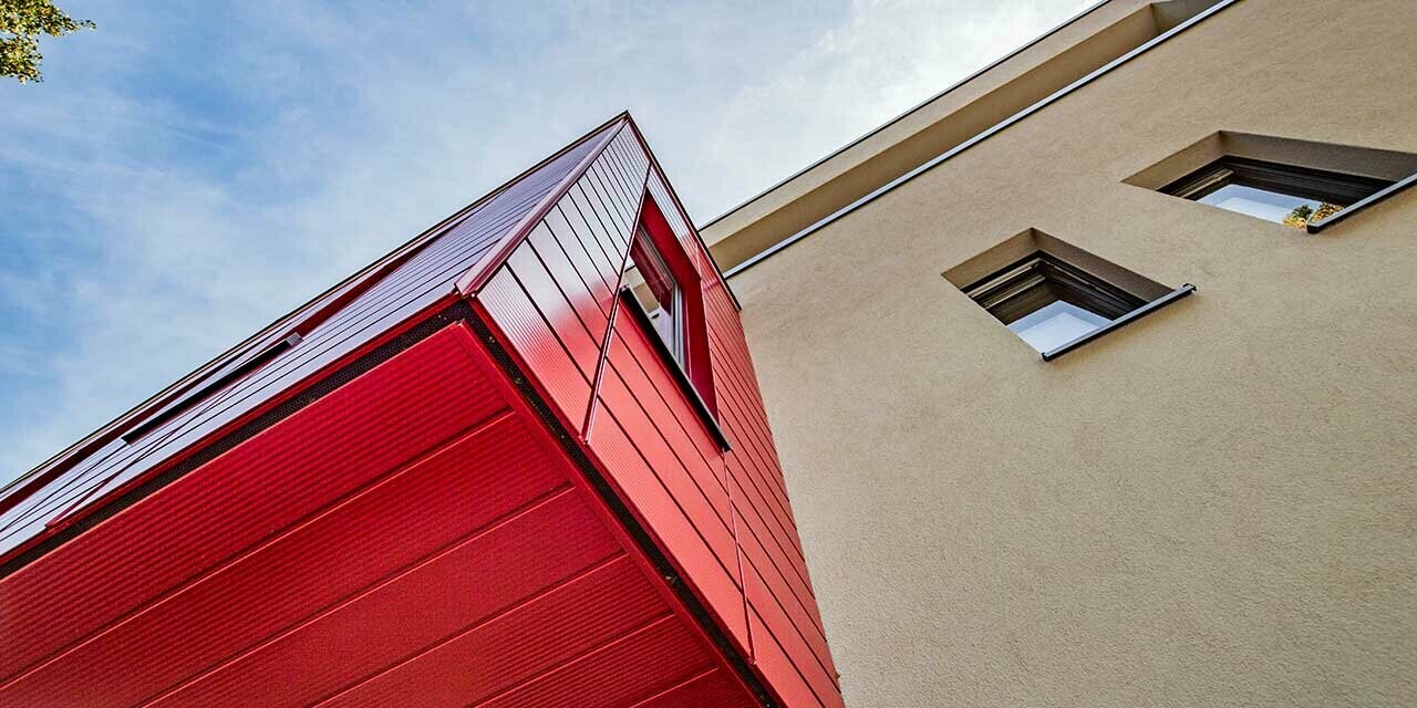 Bay window with lined PREFA sidings in ruby red on a modern detached house in Wernigerode. This photo shows the ceiling of the overhanging extension.