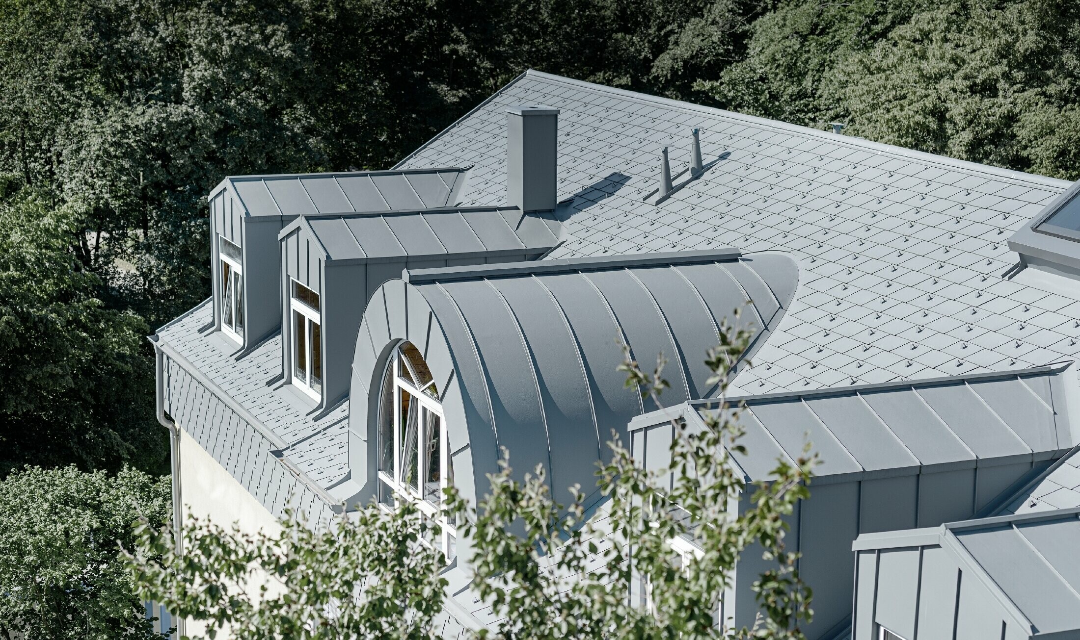 Top floor of the Albertinum in Munich with PREFA roof shingles and standing seam in light grey