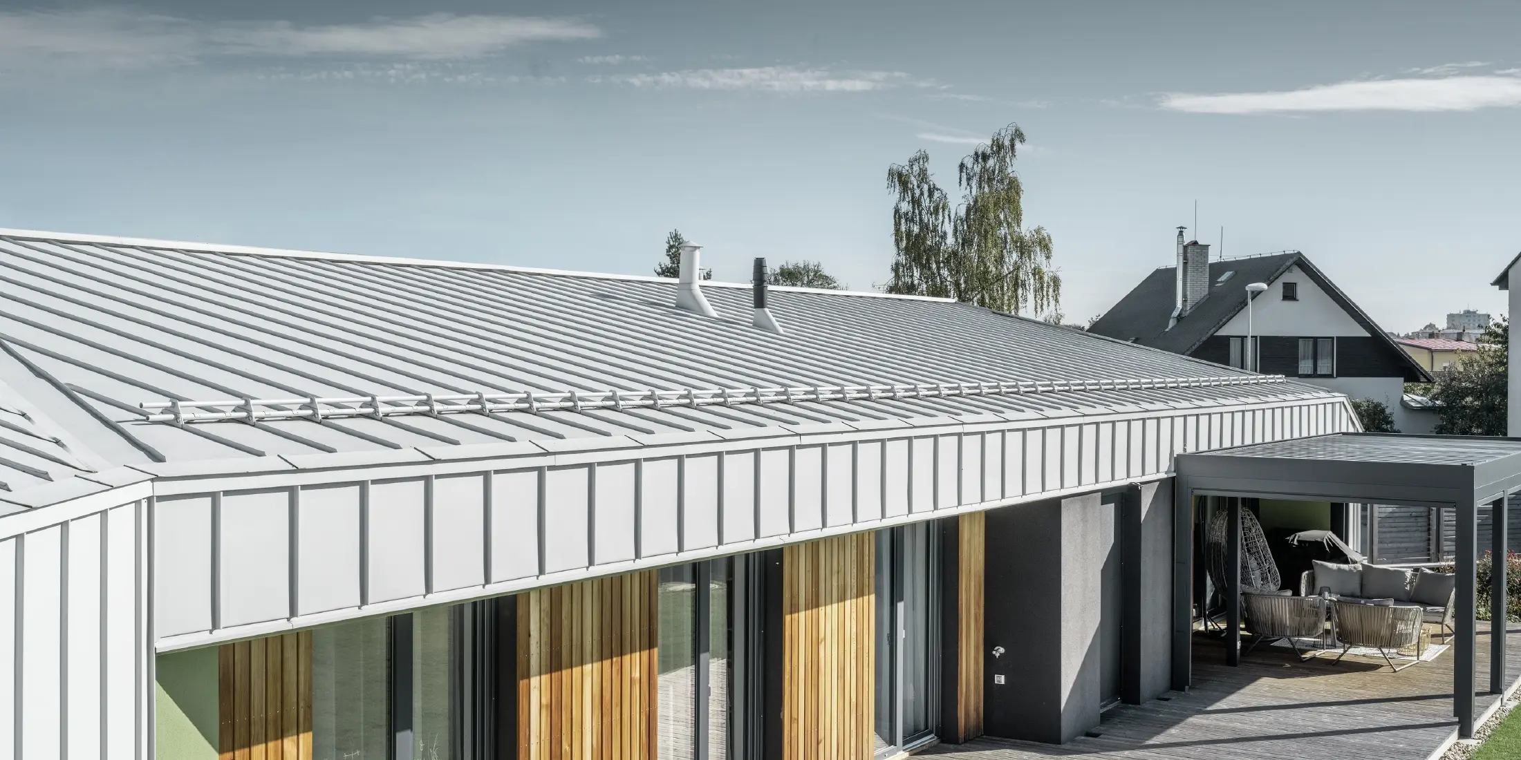 Bungalow with PREFALZ (standing seam) roof and façade in PREFA white and wooden terrace
