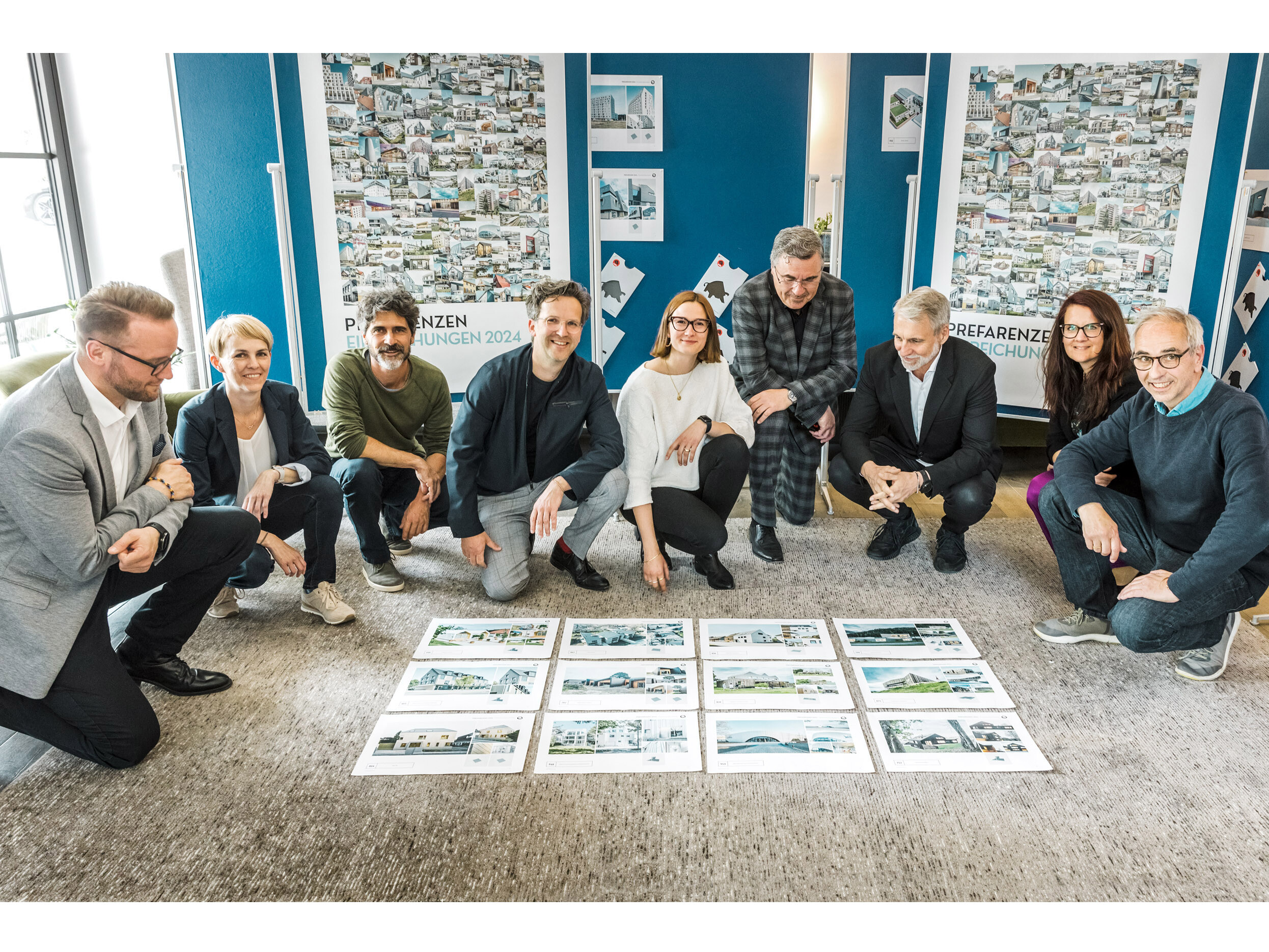 The participants of the PREFARENZEN dialogue, kneeling in front of the project sheets of the twelve selected projects.