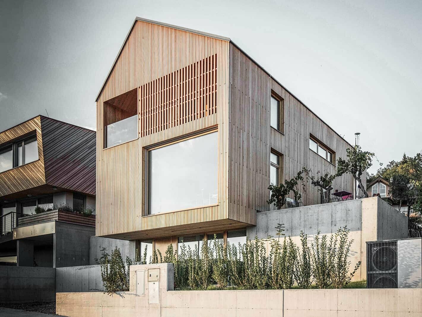 Front view of the detached house. Various formats of windows adorn the building. The used wood natural larch comes into its own.