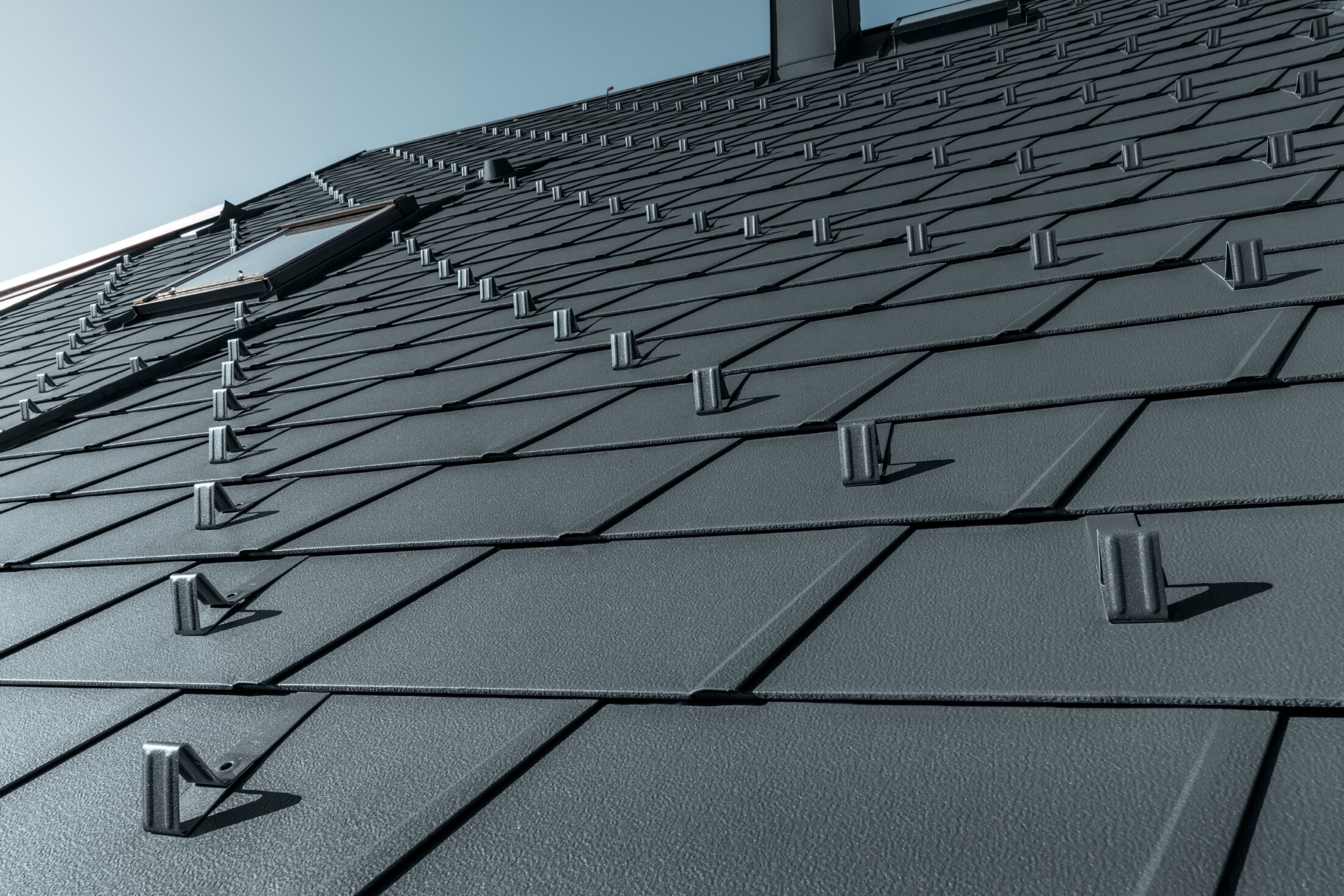 PREFA DS.19 roof shingle in P.10 anthracite with snow stoppers, dormer surrounds and chimney