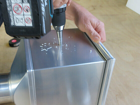 How to create a DIY emergency overflow in a PREFA leader head — Step 2: Pre-drill hole.