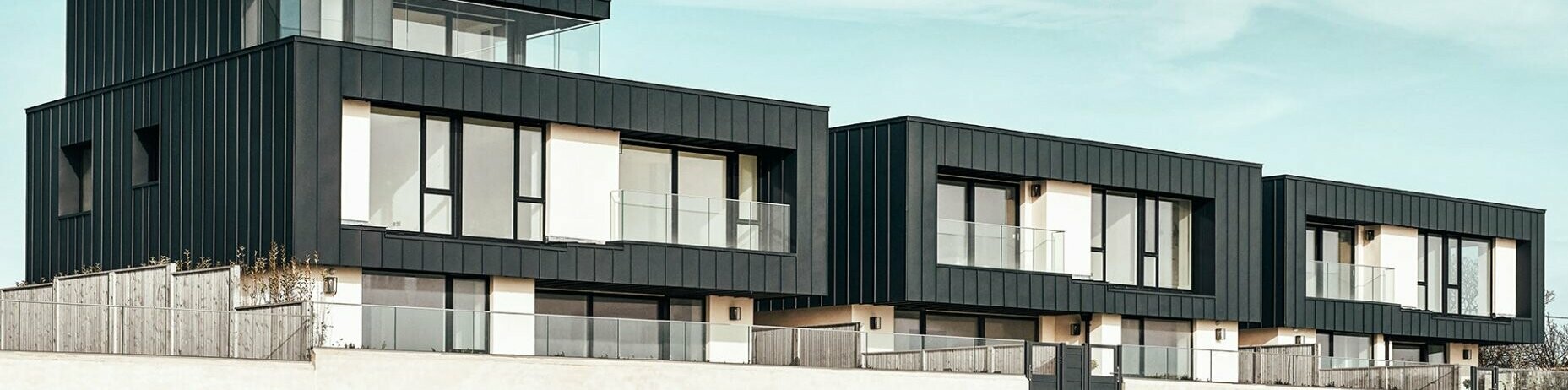 Front view of the three residential houses covered in Prefalz P.10 Anthracite. 