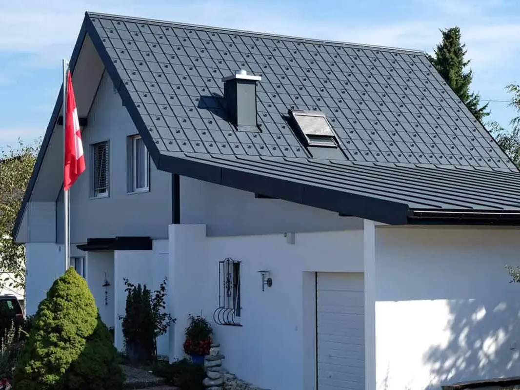 House with a garage after roof renovation with PREFA roof tiles in anthracite