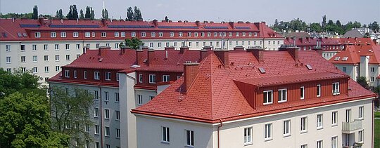 Picture of residential buildings at Hugo Breitner Court in Vienna. These roofs were covered with PREFA shingles in brick red.