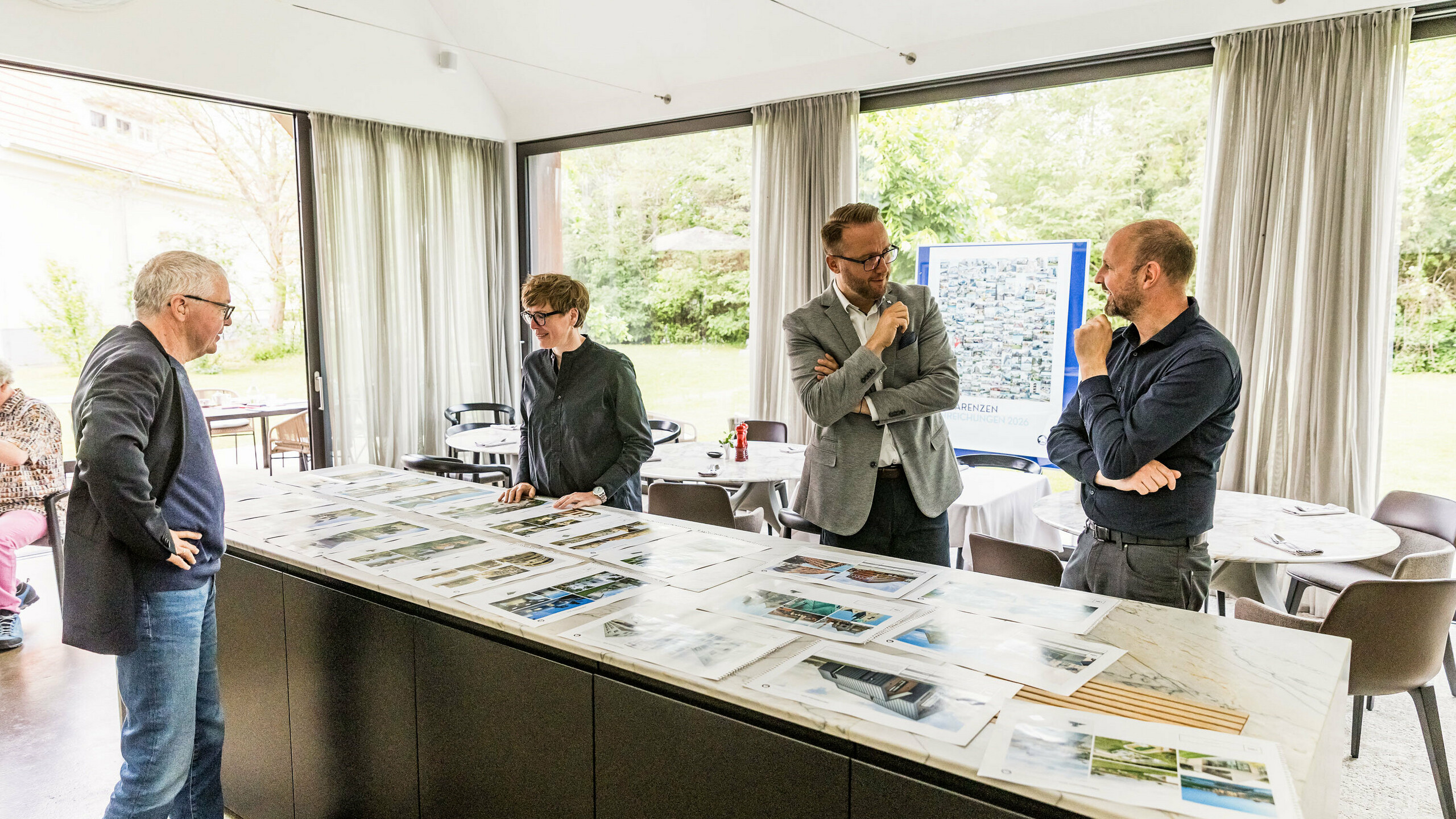 The final selection of PREFARENZEN architectural highlights for 2026 is available in large images from parts of the high-calibre jury. The experts carefully examine the submitted architectural projects for their innovative strength, design quality and use of PREFA materials. The meeting in the light-flooded winegrower's residence in Seewinkel, Burgenland, marks the conclusion of the intensive jury process for the PREFARENZEN architecture book and the 2026 calendar.
