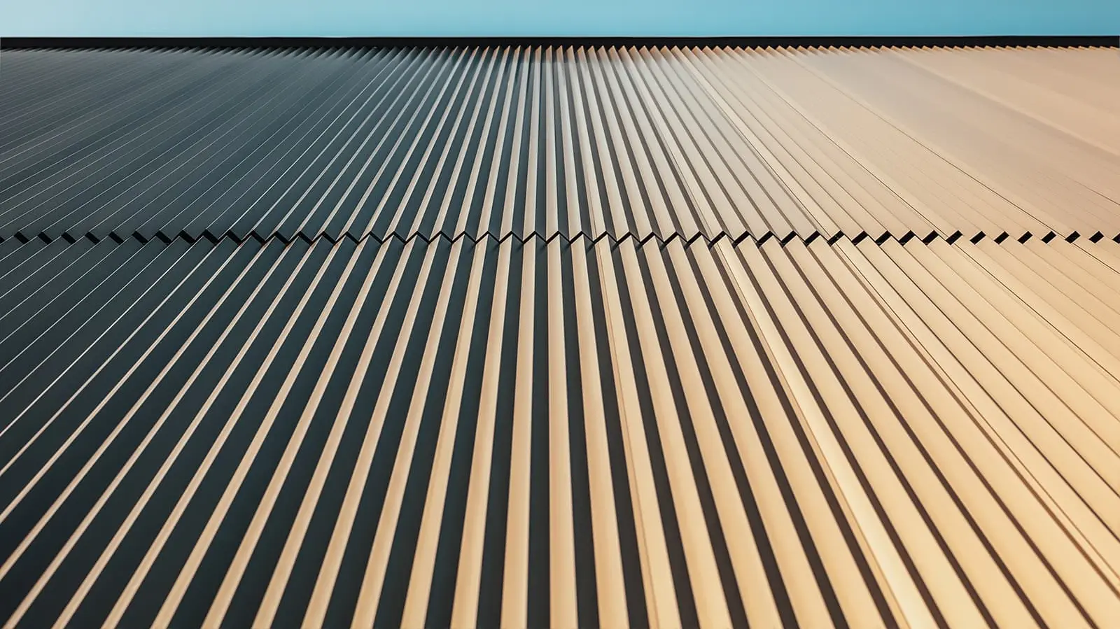 Worm´s eye view of the PREFA façade which was covered with the serrated profile in bronze. The view is up to the sky.