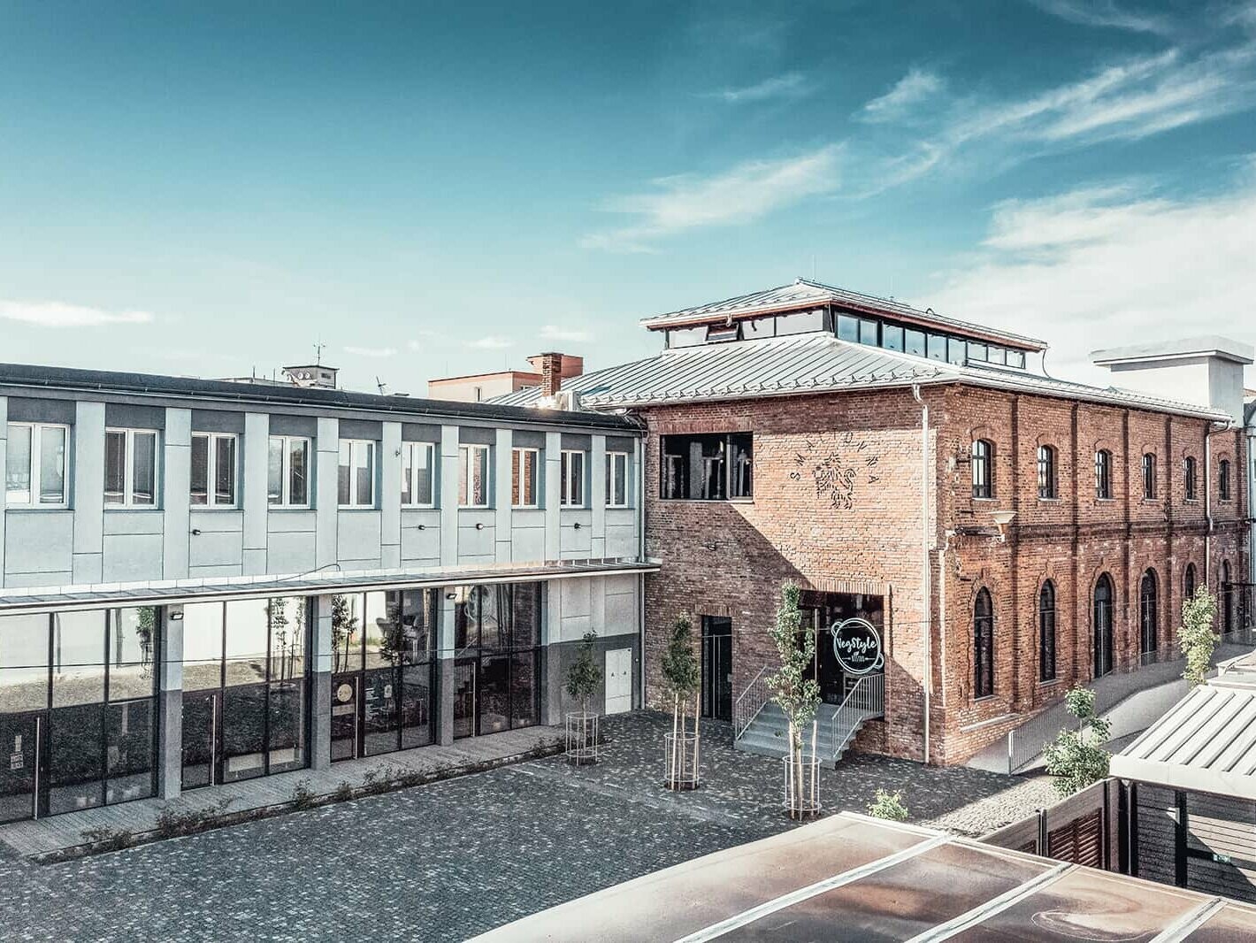 External view of the enamel factory. The façade is made of bricks, the roof is covered in Prefalz plain aluminium. 