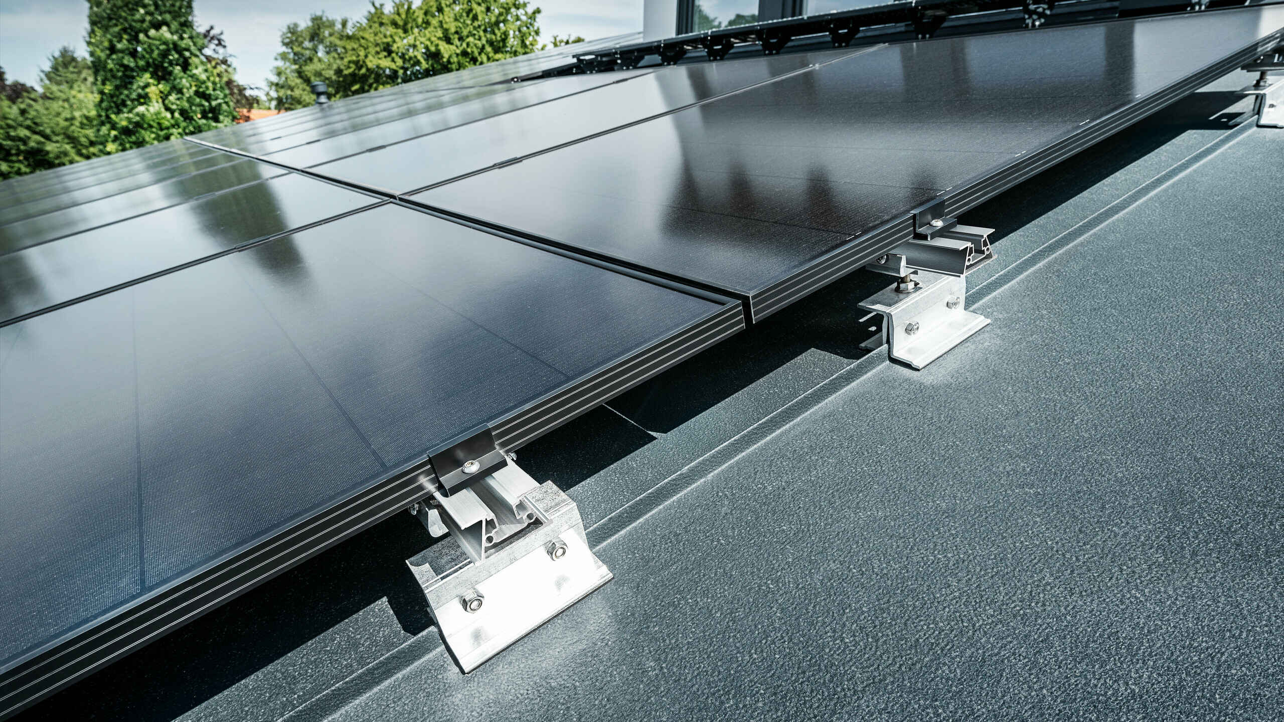 Close-up of the Vario PREFALZ solar bracket on a standing seam roof in anthracite 