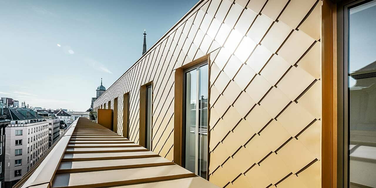 Façade cladding of the Korb Etagen in Vienna with the PREFA 29 x 29 rhomboid façade tile in pearl gold.