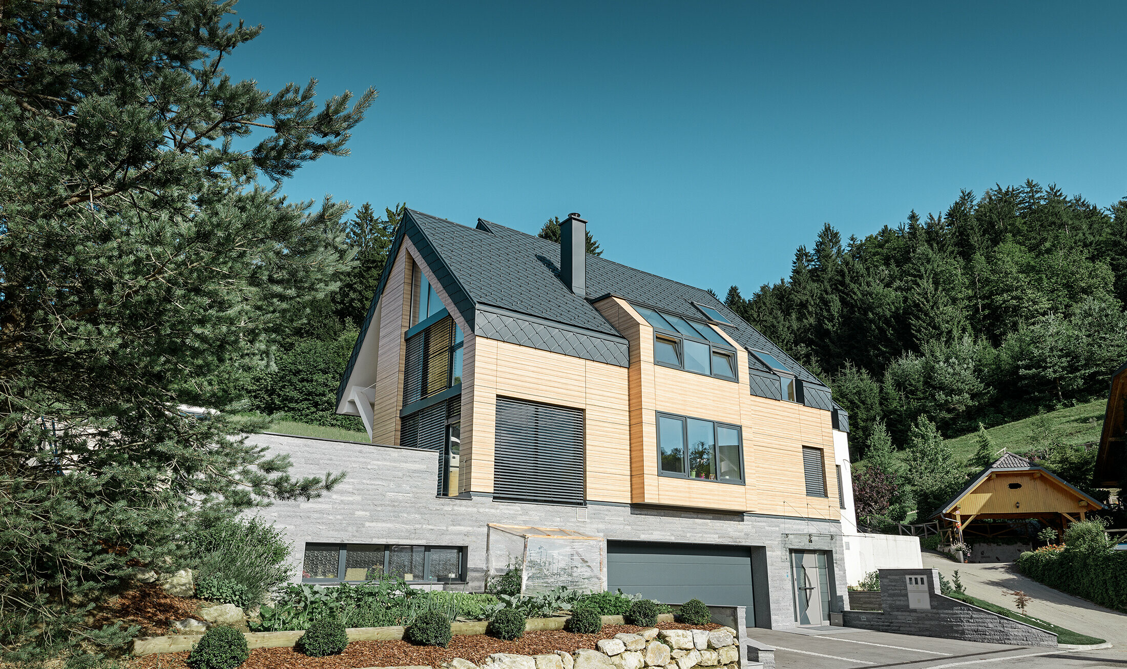 Detached house with gable roof without eaves with a wooden-look façade and an anthracite aluminium roof