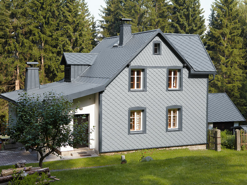 Detached house in a wooded area with a weather-resistant PREFA aluminium façade in light grey.