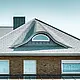Detached house from the 70s with an aluminium shingle roof in P.10 stone grey with curved dormer with round window
