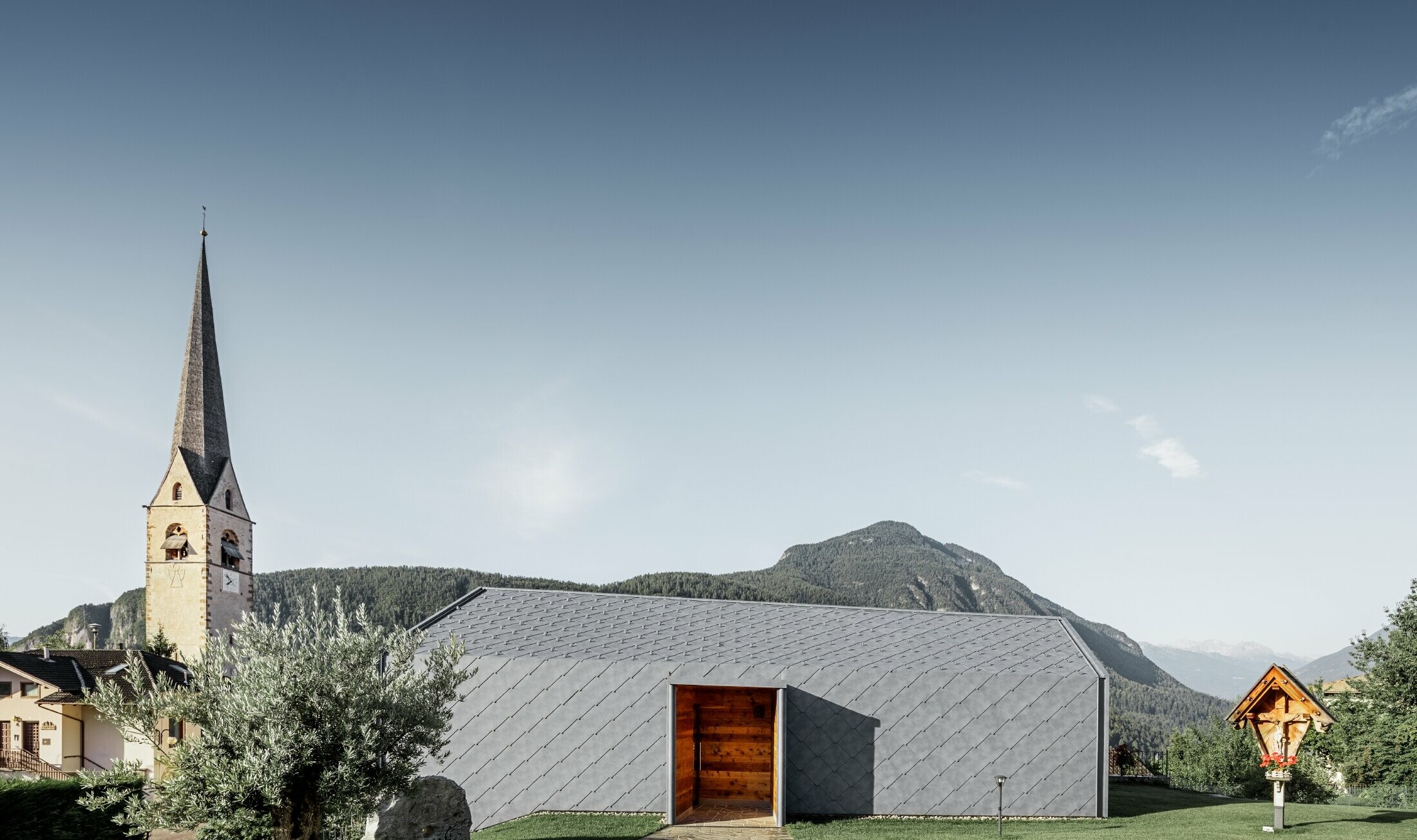 Side view of a hairdressing salon in Livo covered with the PREFA rhomboid tiles for the roof and façade in stone grey